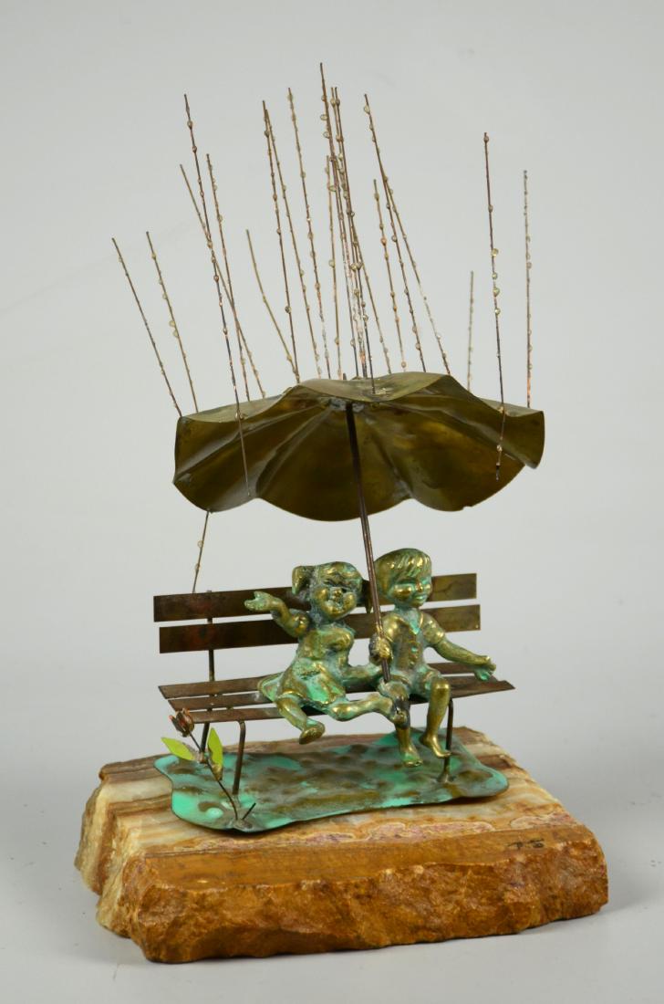Bijan Raindrops Sculpture: Brian Bijan (American, 20th C), Bronze, copper, and brass sculpture ''Rain Drops'', signed "Bijan", mounted to an agate rock base, whimsical sculpture depicting a girl and boy on a park bench under an