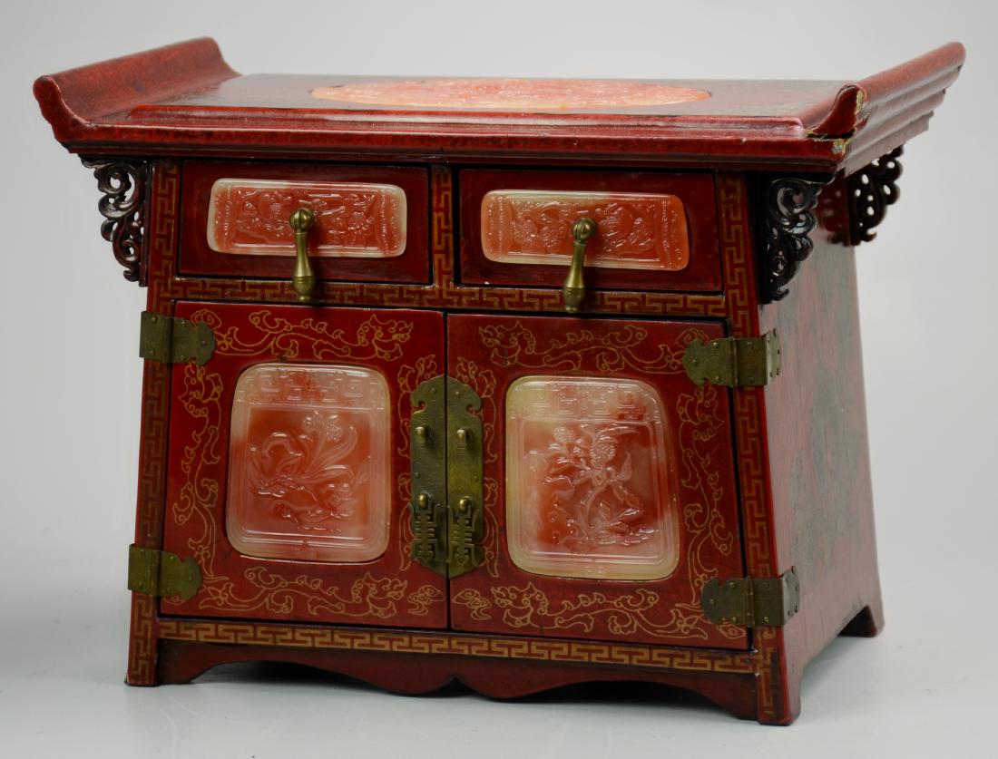 Chinese Jewelry Chest Stone Inserts: Red painted Chinese jewelry chest with pink carved stone inserts, 2 drawers over 2 doors concealing 3 drawers, brass mounts, 13-3/4" w x 7-1/2" d x 10" h