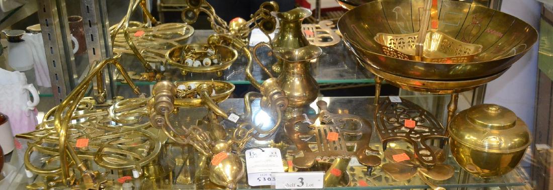 Shelf #3 - Brass Items: Shelf #3 - Brass Items Including Brass India Bowl, Black and Brass Leaf Bowl, Trivet Marked Cymru, Lipton's British Empire Tea Caddy, (2) Early Trivets, (2) Wall Candle Holder