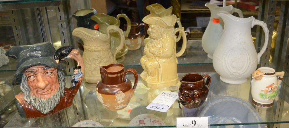 Shelf #9 - (7) Pitchers: Shelf #9 - (7) Pitchers, including Royal Doulton Rip Van Winkle toby jug, yellow glaze Cooper Clayton by Sterling toby, Doulton Lambeth 0115, treacle glaze face pitcher, W Ridgway & Co tavern pitcher