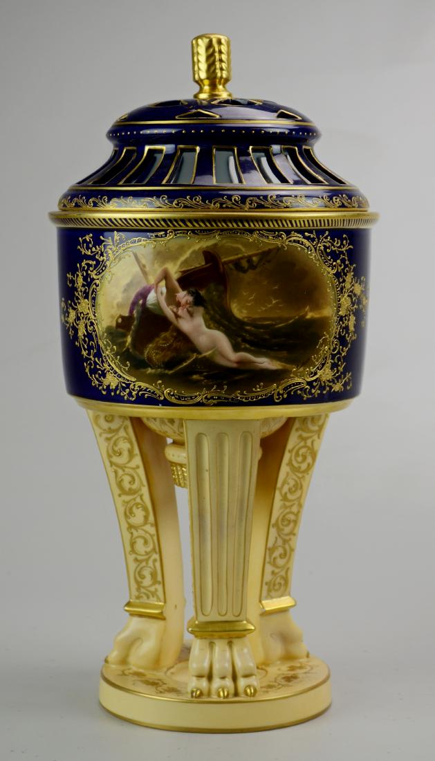 Gilt Cobalt Continental porcelain covered urn: Continental porcelain covered urn, cobalt body and lid, pale gold base, all with gilt highlights, the body HP with a scene "Waves Kiss", artist signed, reticulated lid, no makers mark, titled to base,
