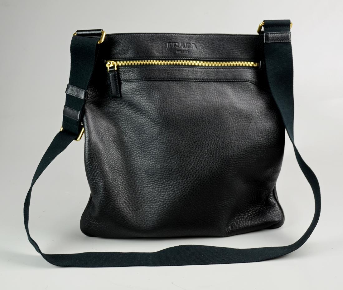 Prada Black Leather Messenger: Black leather Prada oversized messenger. Black adjustable fabric strap with gold hardware. Approx 13.5"x13".