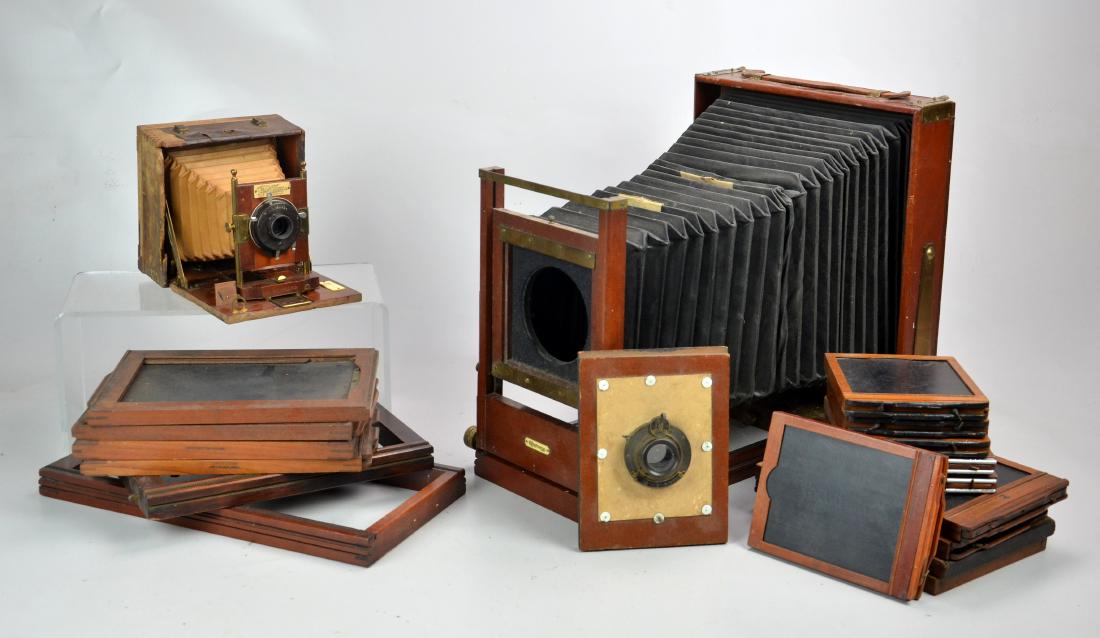 2 Wood Folding View Cameras and Accessories: Brass and wood constructed large format view camera manufactured by Century of Rochester NY. Bellows show signs of wear, rear standard os on tact. Smaller wood construction view camera manufactured by