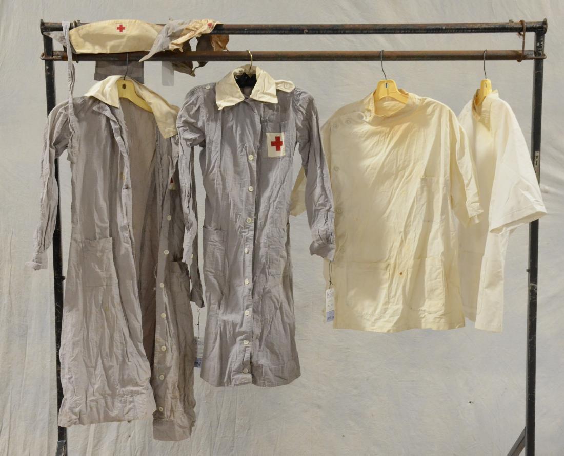 WWII Era Red Cross Uniform and Hat Pair: Pair of early cotton seersucker Red Cross uniforms. M.O.P buttons, waist belts and (1) hat. Tags read as following, " Serving Those Who Serve Humanity, Stein Uniform Co." Also to include (2) vintage p