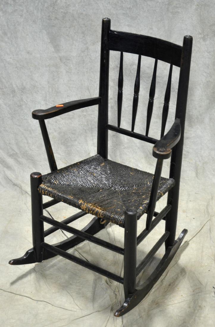 Black painted child's double bearing armed rocking: Black painted child's double bearing armed rocking chair, rush seat, early 19th c, 34-1/2"h