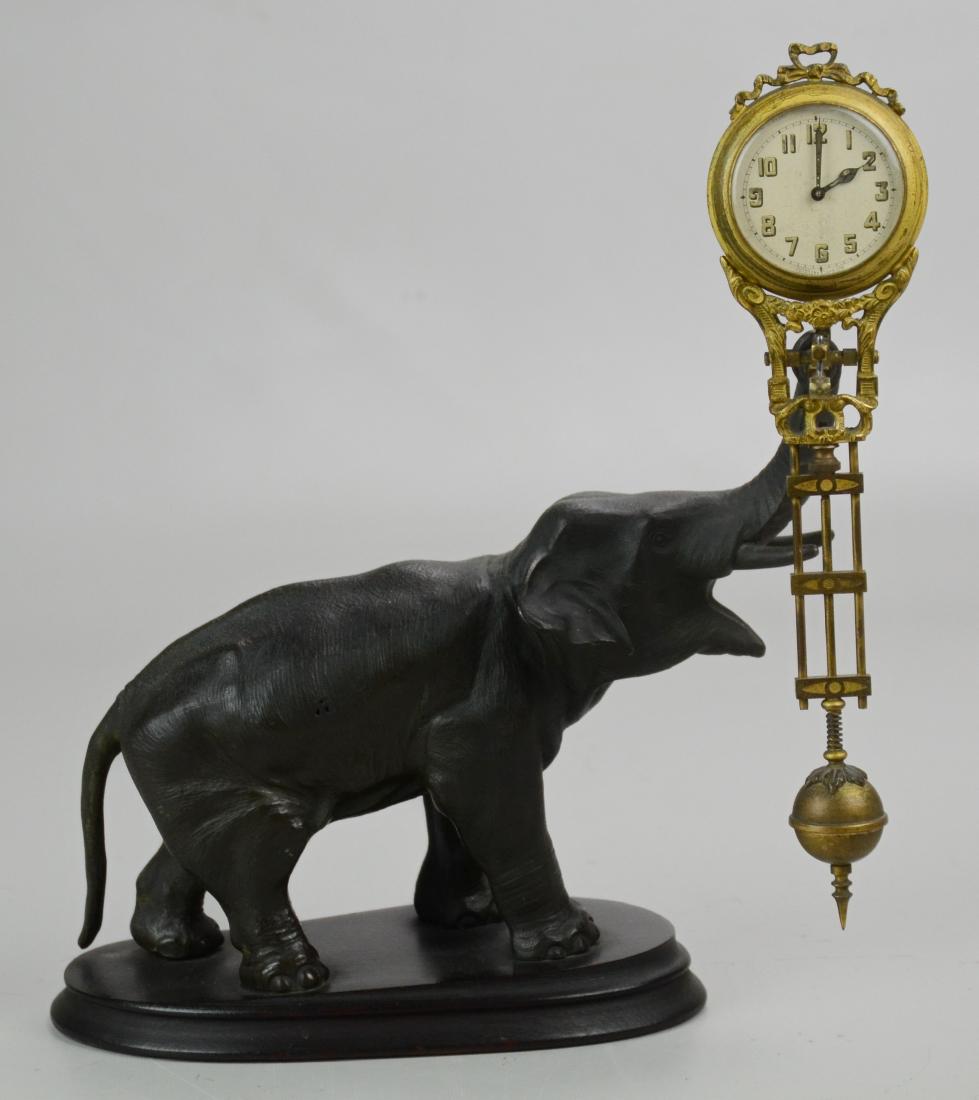 Junghans Swinging Elephant Clock: Spelter Junghans Swinging Elephant Clock Includes Extra Jewel Bar (9-1/2" l x 3-1/2" w x 11-1/4" h), (Clock is Not Working at Time of Cataloging, Front Part of Clock Case Does Not Stay On)