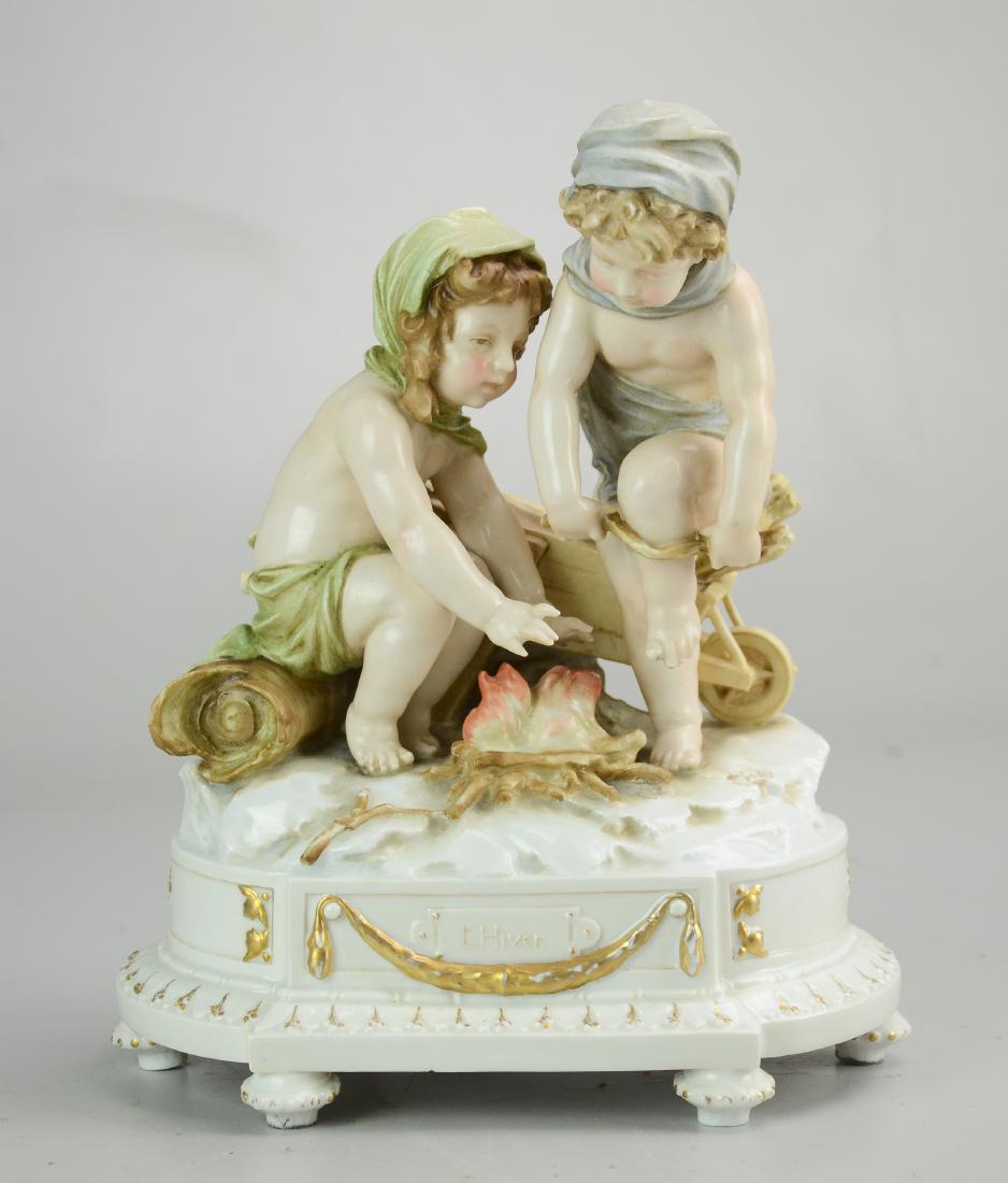 Ens Porcelain Boy & Girl with Fire FIgure: Karl Ens porcelain figurine, L'Hiver (the winter), two children building a fire, marked on back "E Jammes", impressed mark to base, 9-1/2" h, one handle of wheelbarrow broken off, some wear to gilt tr
