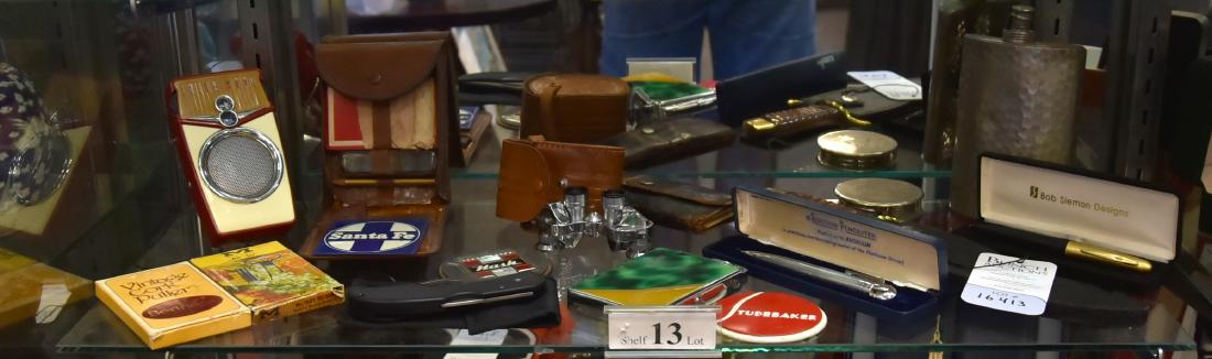 Shelf #13 - Pens, Lighters and Knives: Shelf #13 - Ronson Penciliter, Enameled Cigarette Holder with Lighter, Bob Siemon Designs Pen, Jason Binoculars 6x15, Beach Boy Transistor Radio, Hip Flask, Bottle Openers, Fishing flies, Lord and Tay