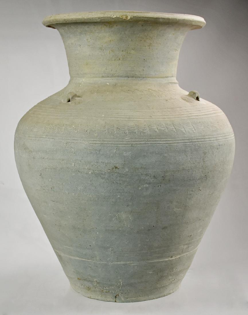 Earthenware Storage Jar: An unglazed gray earthenware storage jar with base, short neck, the mouth with flaired, rolled lip. The body decorated with four lugs and bands of indented scratch motif, Thailand, Satchanalai. Size 1