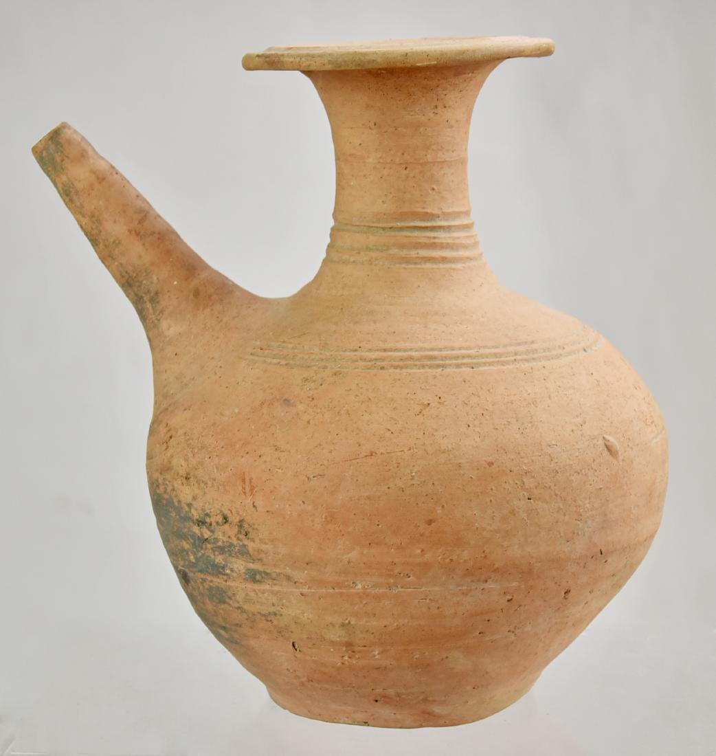 Earthenware Kendi: An earthenware Kendi with globular body and button foot, narrow spout, tall neck and flared mouth with wide, flat lip, the body decorated with narrow bands, Thailand, Sawankhalok. Size 10"