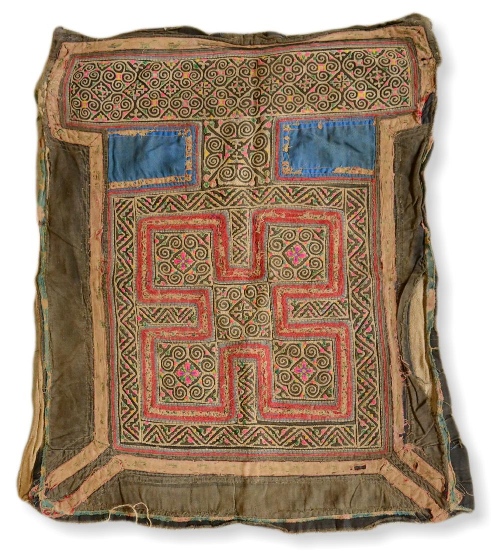 Tribal Embroidery From The Mien/Yao Tribe: A rare indigo-lined, apron of red, yellow, green and black stitching on a cream ground with two indigo squares below a wide waist band and a green surround. A tribal embroidery from the Mien a.k.a. Ya