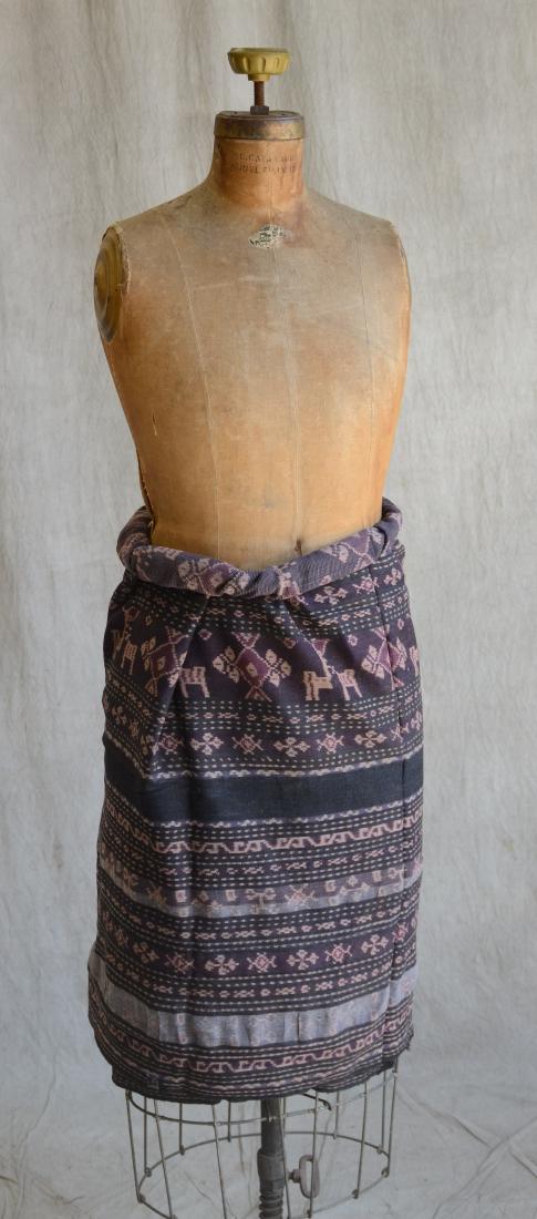Indonesian Woven Cotton Flores Sarong: A finely woven cotton Flores sarong, decorated with multiple stripes filled with chains of leaves, flowers, animals and various geometric motifs within a black ground, interspersed with two black band