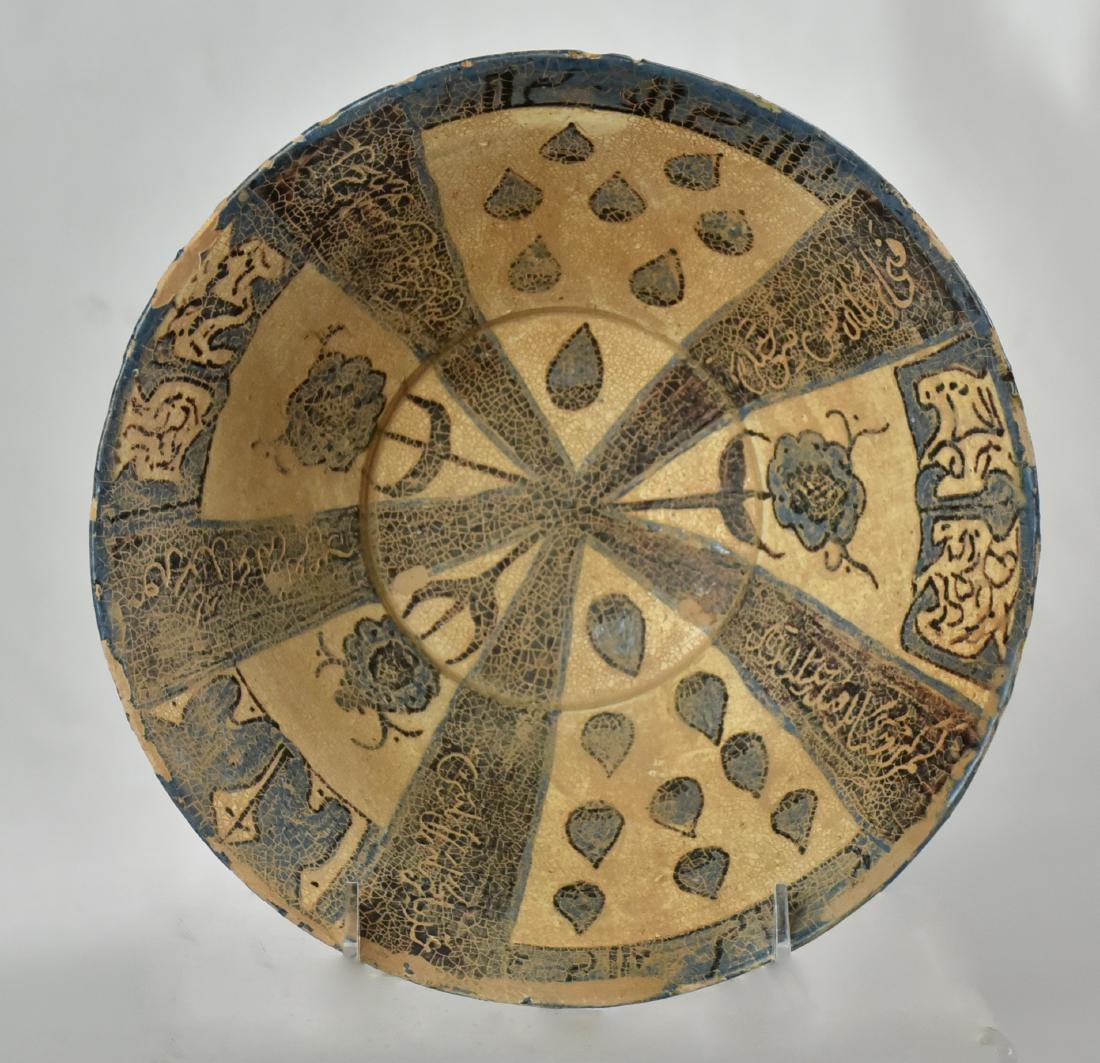 Afghan Serving Bowl: A brown, blue and white under-glazed stoneware serving bowl with flared sides, decorated with wedges of varied motifs, divided by calligraphic spacers and a floral central medallion, Afghanistan. Size