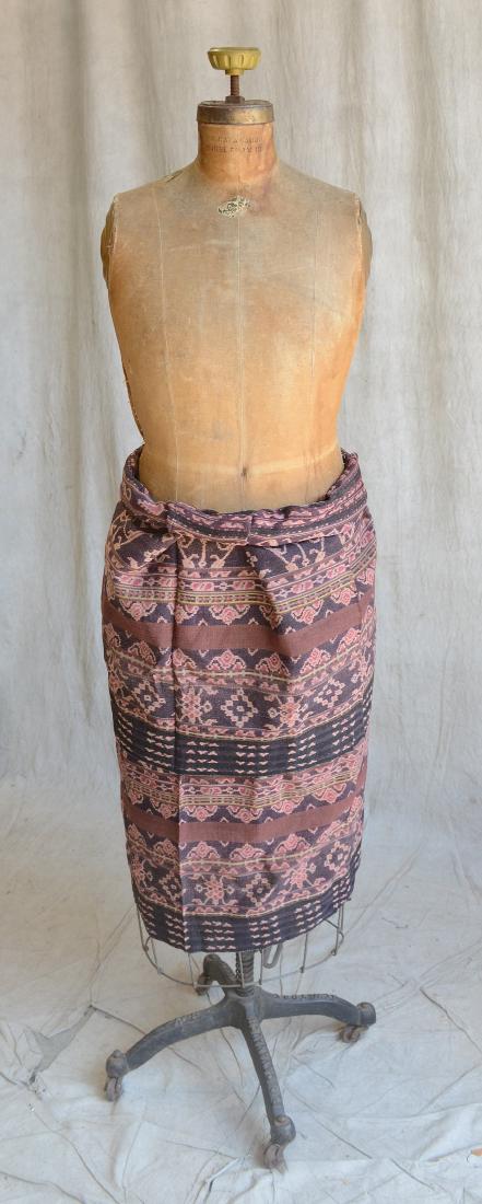 Indonesian Brown And Kombu Dyed Cotton Sarong: A finely woven, dark brown and kombu dyed, cotton tubular sarong, decorated with columns filled with floral bouquets, interspersed with smaller flowers, diamonds and other geometrical motifs, trimmed 
