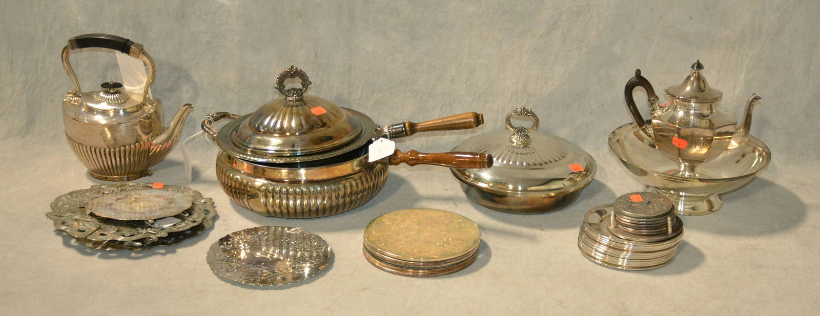 Silverplate Grouping: Silverplate grouping to include several trivets, (13) small plates, coasters, (2) handled dishes, (1) with cover, (1) covered dish, (1) bowl and (2) tea pots.