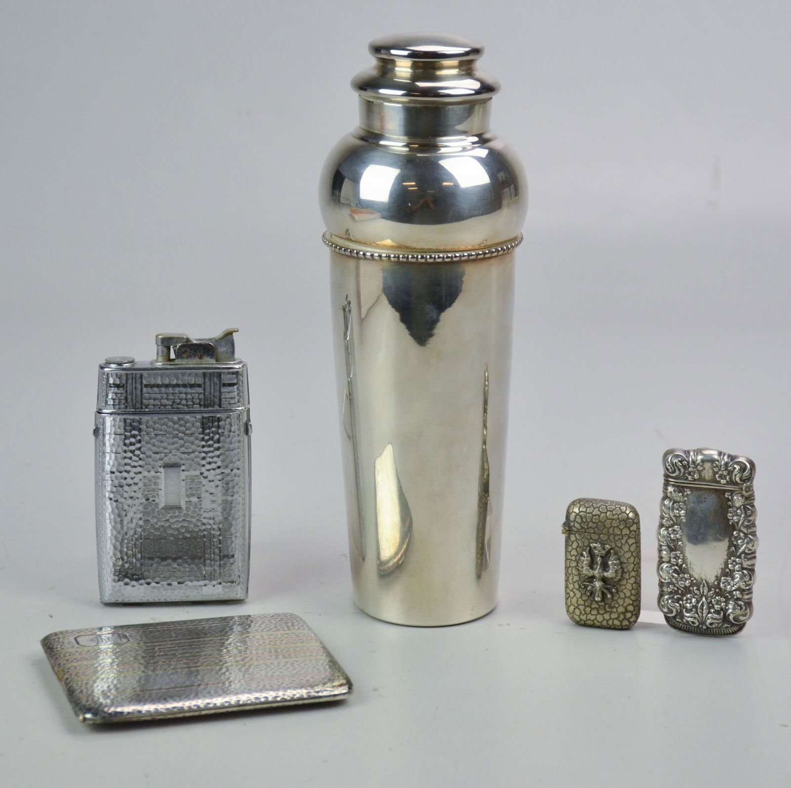 Smoking and Drinking Set Including Sterling Silver: 14k Gold and Sterling Silver Cigarette Case, Sterling Silver Match Vesta Case, Match Safe with Bird with Crown Mark, Silverplate Cocktail Shaker, Evans Lighter and Cigarette Holder (4.5 TO)