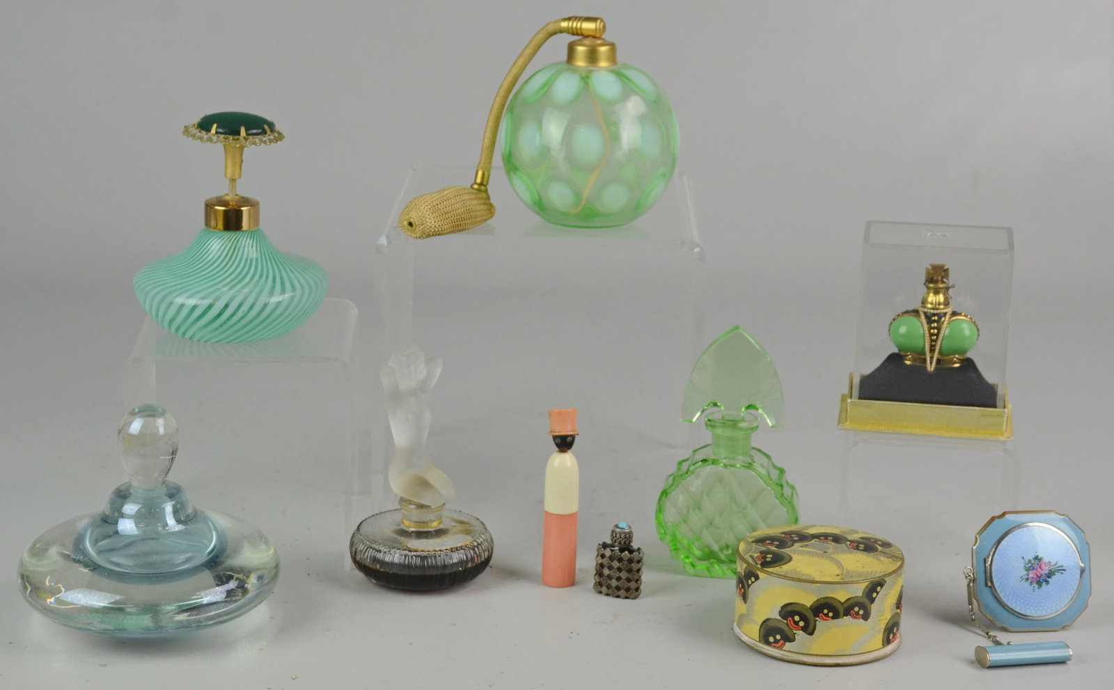 (10) Perfume Bottles & Powders: (10) Perfumes & powders, c/o Fenton opalescent swirl, coinspot atomizer, art glass, green depression, frosted nude, Windsong crown (in original packaging), bakelite figural, Vigny Golliwogg powder, mi