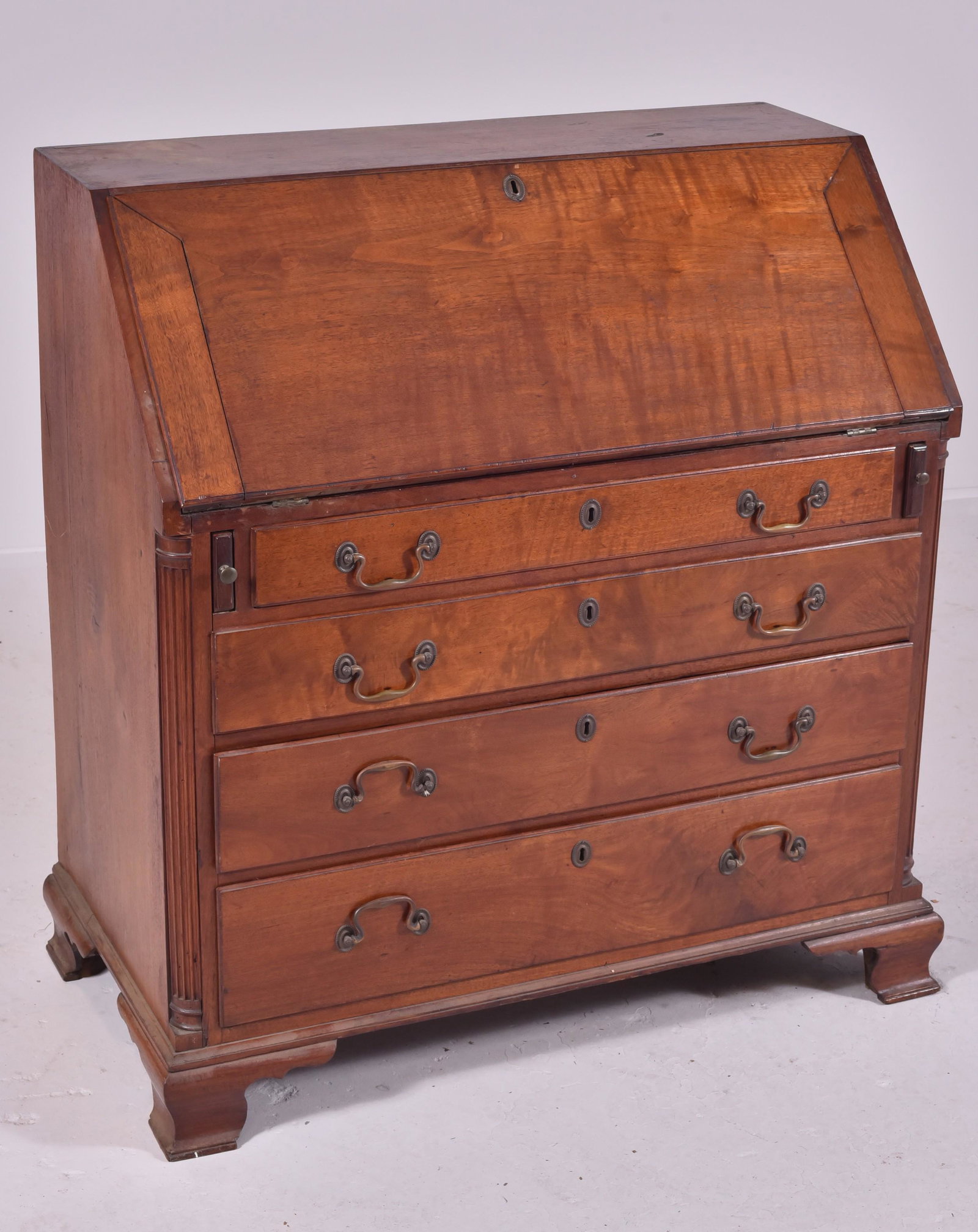Walnut Chippendale slant lid desk: Walnut Chippendale slant lid desk, fall front of figured walnut over 4 lipped graduated drawers, replaced brasses, flanked by inset fluted corner columns on OGEE feet, flat interior with string inlay,