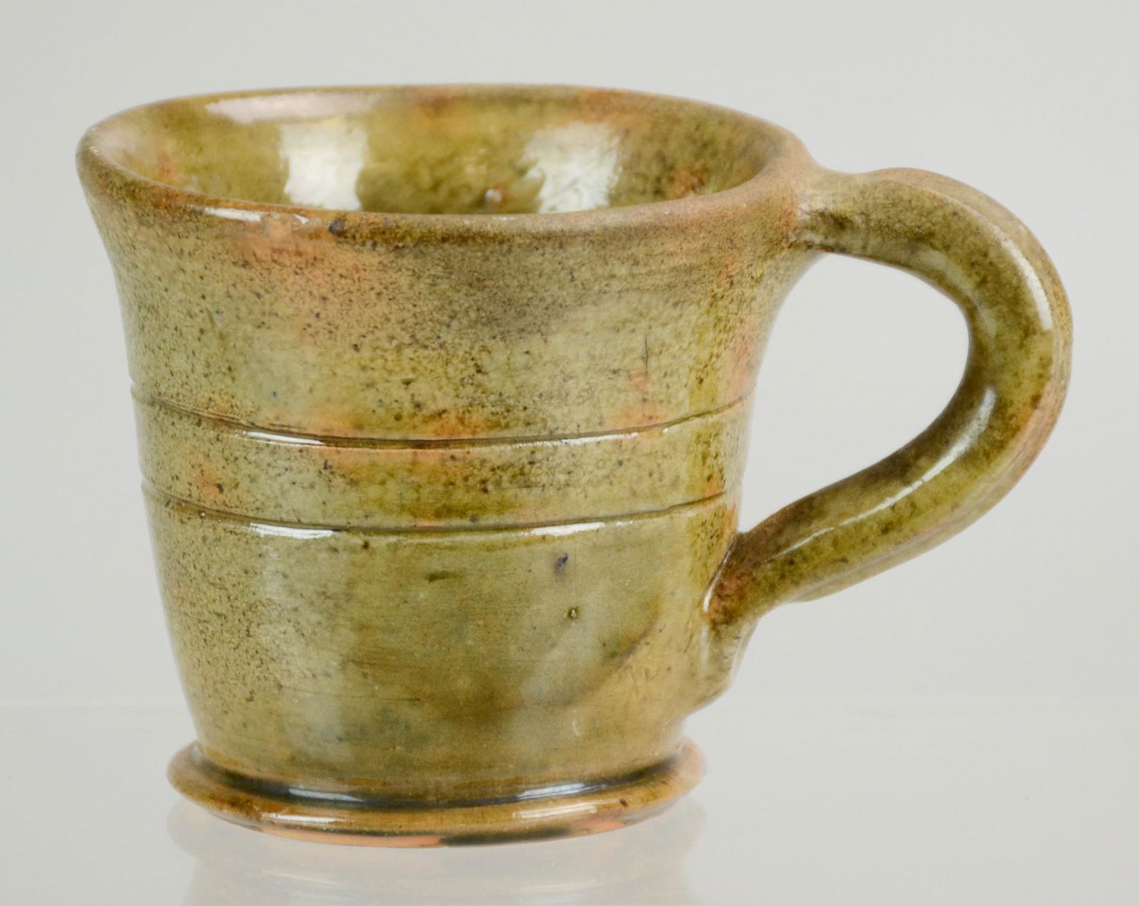 Stahl Pottery Glazed Redware Mug, "Made in Stahl's: Stahl Pottery Glazed Redware Mug, "Made in Stahl's Pottery by Thomas Stahl, April 13, 1937", tapered body with incised band and applied loop handle. 3-1/4"h.