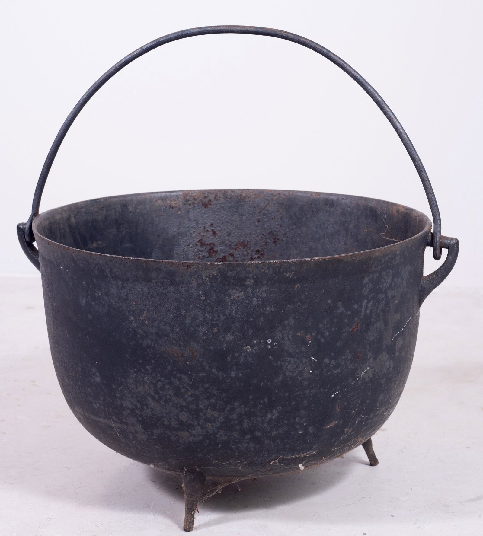 Cast iron footed kettle with swing handle: Cast iron footed kettle with swing handle, 23-1/2"diameter x 16-1/2"h