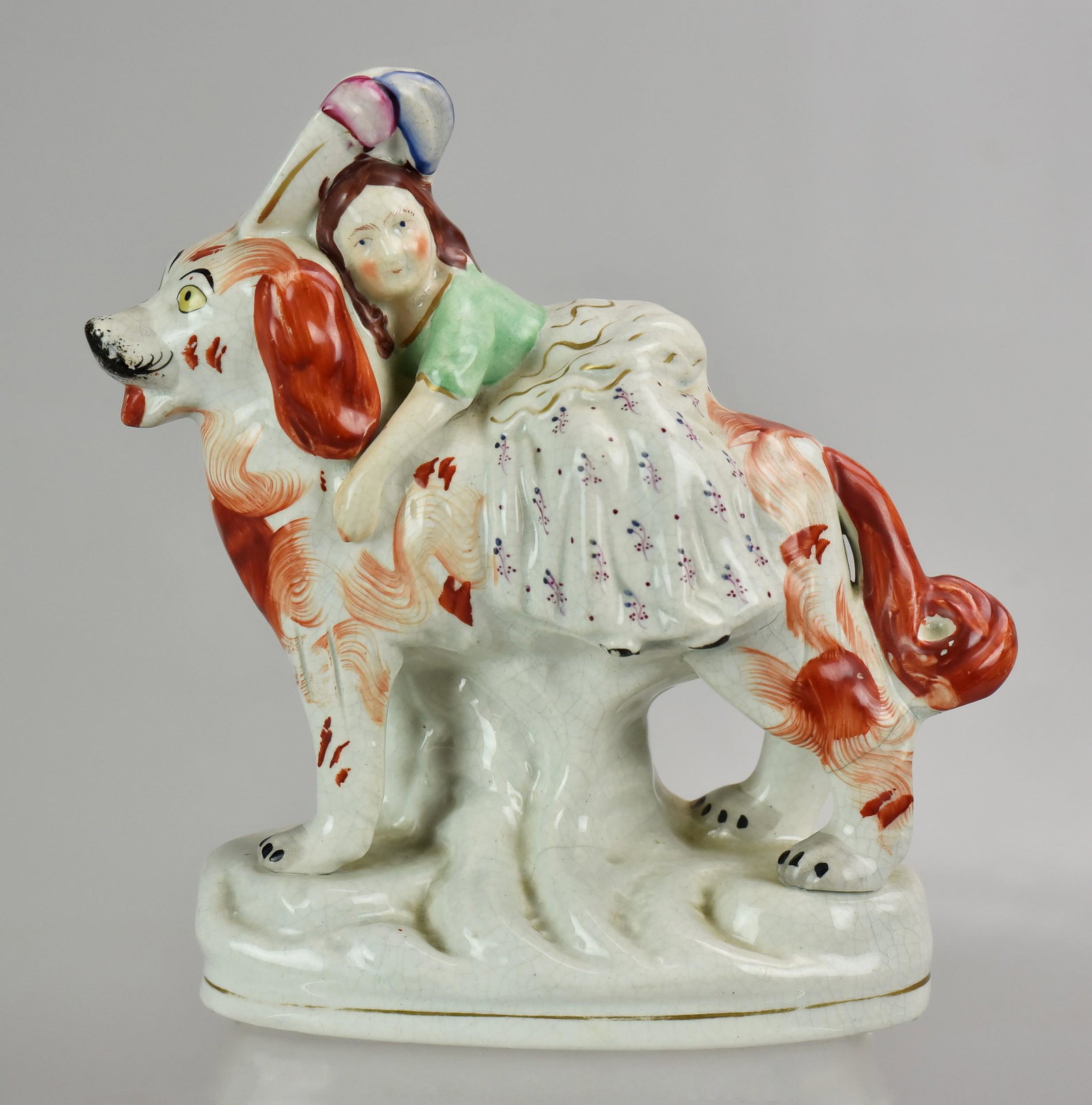 Staffordshire Figure of Young Girl Sitting on Dog: Staffordshire Figure of Young Girl Sitting on Dog (8-3/4" h x 8" l)multiple hairlines in base, chip at rear of base with some repair