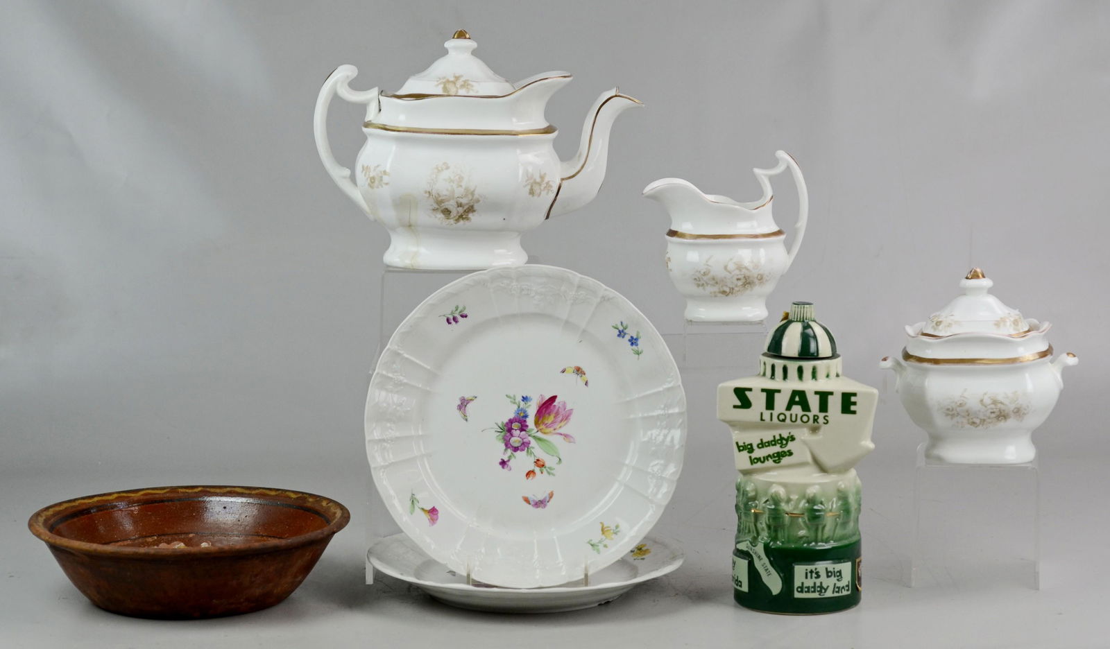 (7) Pcs. Porcelain and Pottery: Paris porcelain teapot, creamer and sugar, (2) hand painted KPM floral plates 10" dia., an Ezra Brooks "Big Daddy's Lounge" liquor decanter, and Mexican redware plate