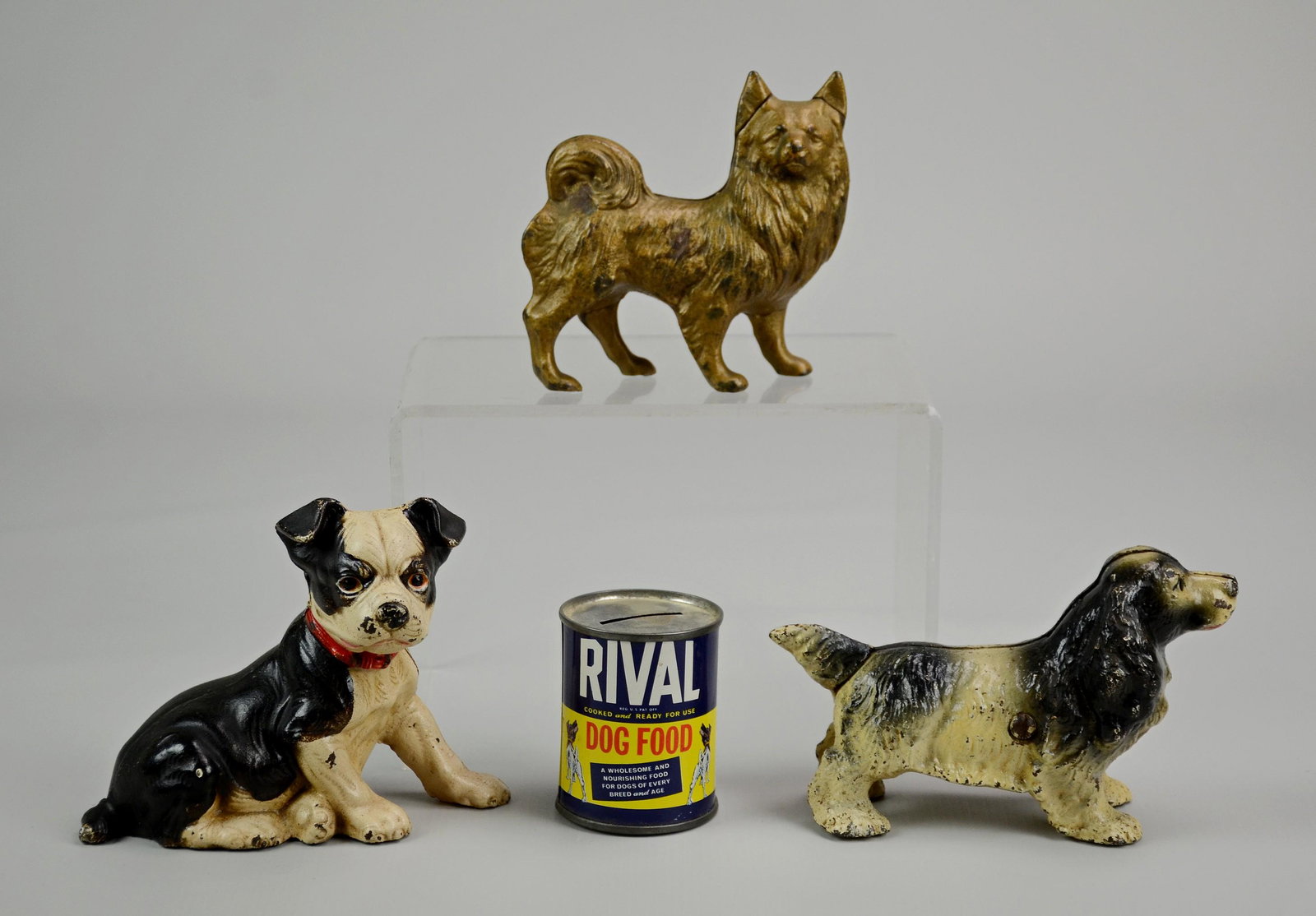 (3) Cast Iron Dog Banks and (1) Rival Dog Food Bank: (3) Cast Iron Dog Banks Including: Cocker Spaniel, Boston Terrier, and Gold Tone Dog (Tallest 4-3/4" h), (1) Rival Dog Food Bank (2-3/4" h)