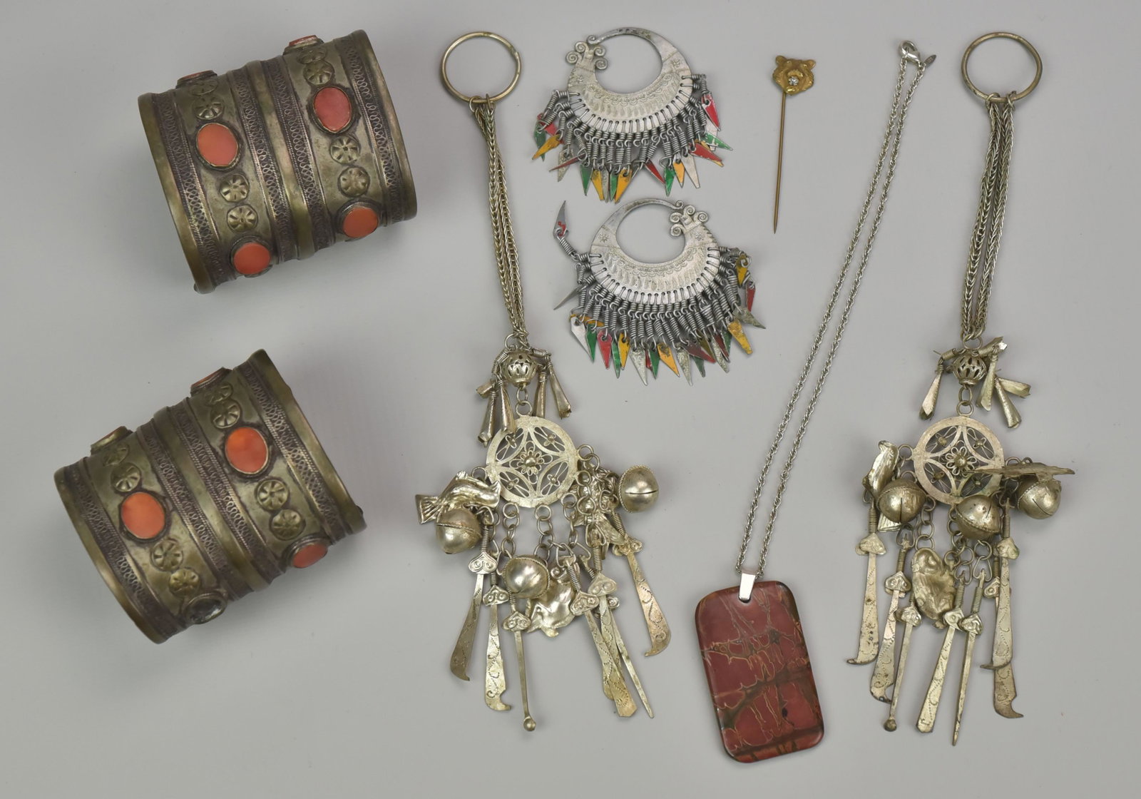 Silver and Silver Tone Jewelry: (2) Silver Asian Cuffs with Orange Stones (8/1 TO Total Weight), (Missing One Stone), Silver Tone Ethnic Charm Bracelets and Earrings, Silver Tone Necklace with Red Stone Pendant with Silver Bail, Cos