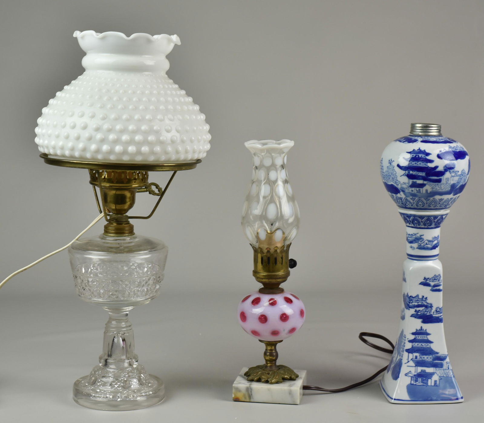 (3) Oil Lamps: (3) Oil lamps, c/o cranberry opalescent coinspot (electrified), clear pattern glass with hobnail milk glass shade, Ironstone Blue Willow, tallest 17-1/2"