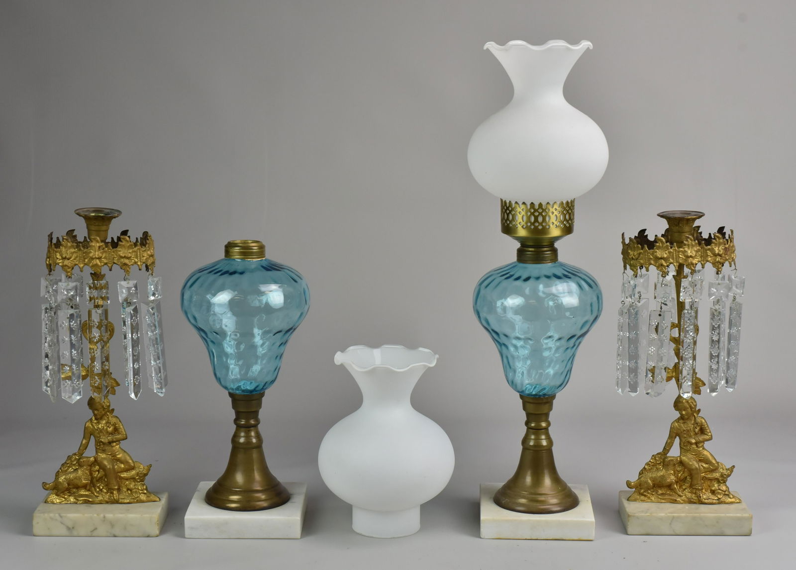 Gilt Metal Figural Candlesticks and Oil Lamps: Gilt metal figural candlesticks and oil lamp pair. Sticks depicting boy and dog with marble base, gilt halo and crystal drop surround, 14" H. Also including blue glass oil lamp pair with brass mounts,