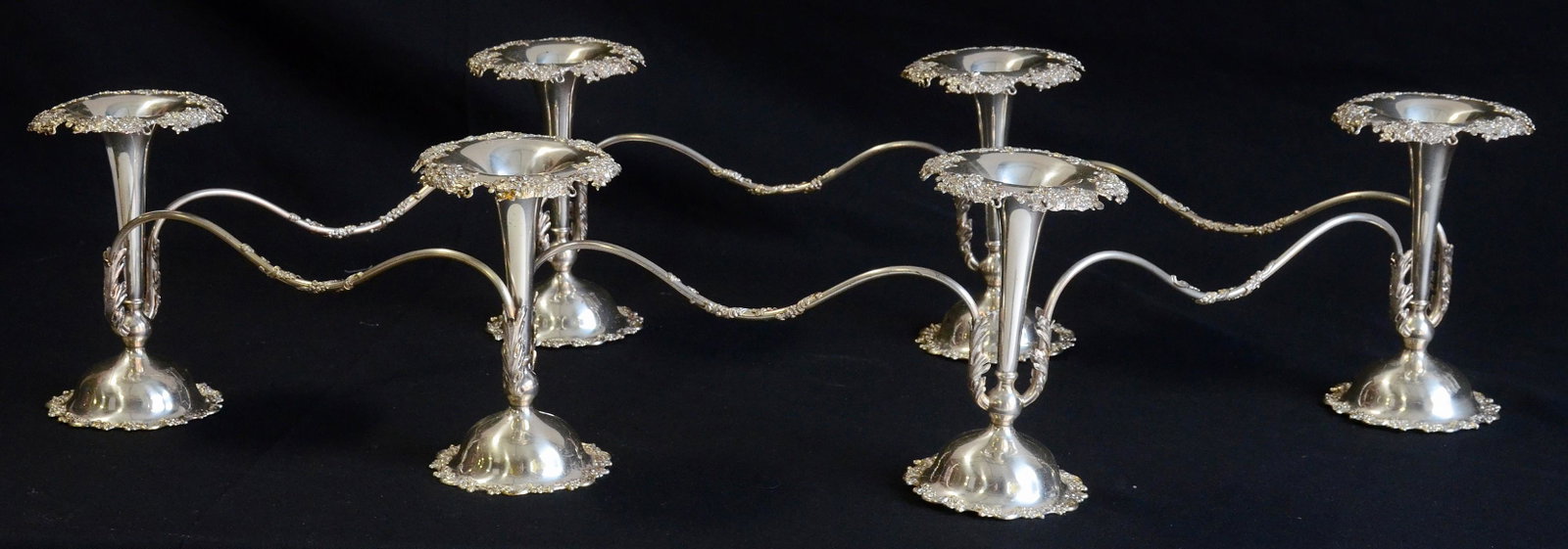 Mauser Mfg Co sterling silver centerpiece: Mauser Mfg Co sterling silver centerpiece, comprising (6) footed flower vases with floral borders, all joined by tubular arms to form a circular arrangement about 30" in diameter, the vases 8" h, 5" d
