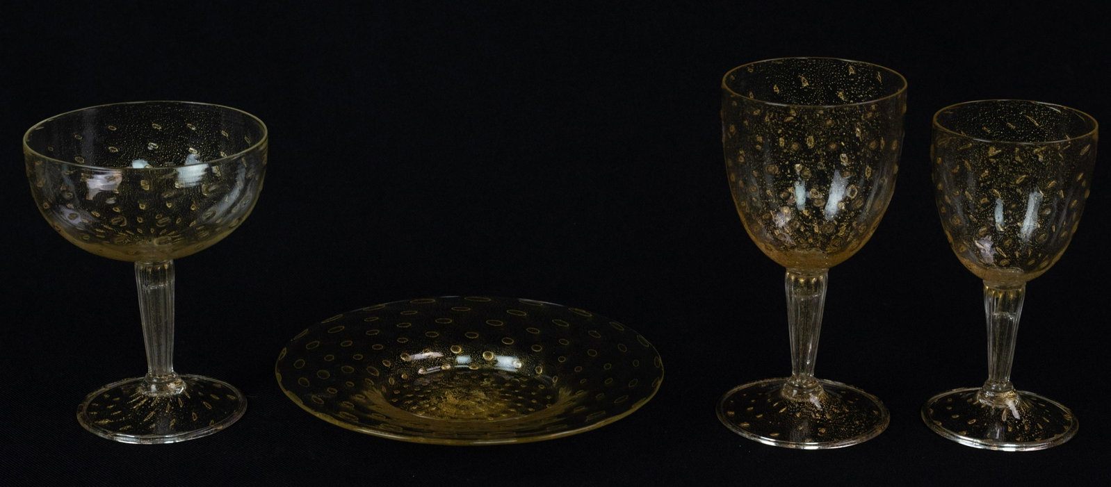 22 pcs Venetian Gold Flecked Glassware: 22 pcs Venetian glass, gold flecked controlled bubble, c/o (6) 6" red wine goblets, (5) 5-3/8" white wine glasses, (5) 5" champagne saucers/tall sherbets, (6) 6-3/4" dia plates