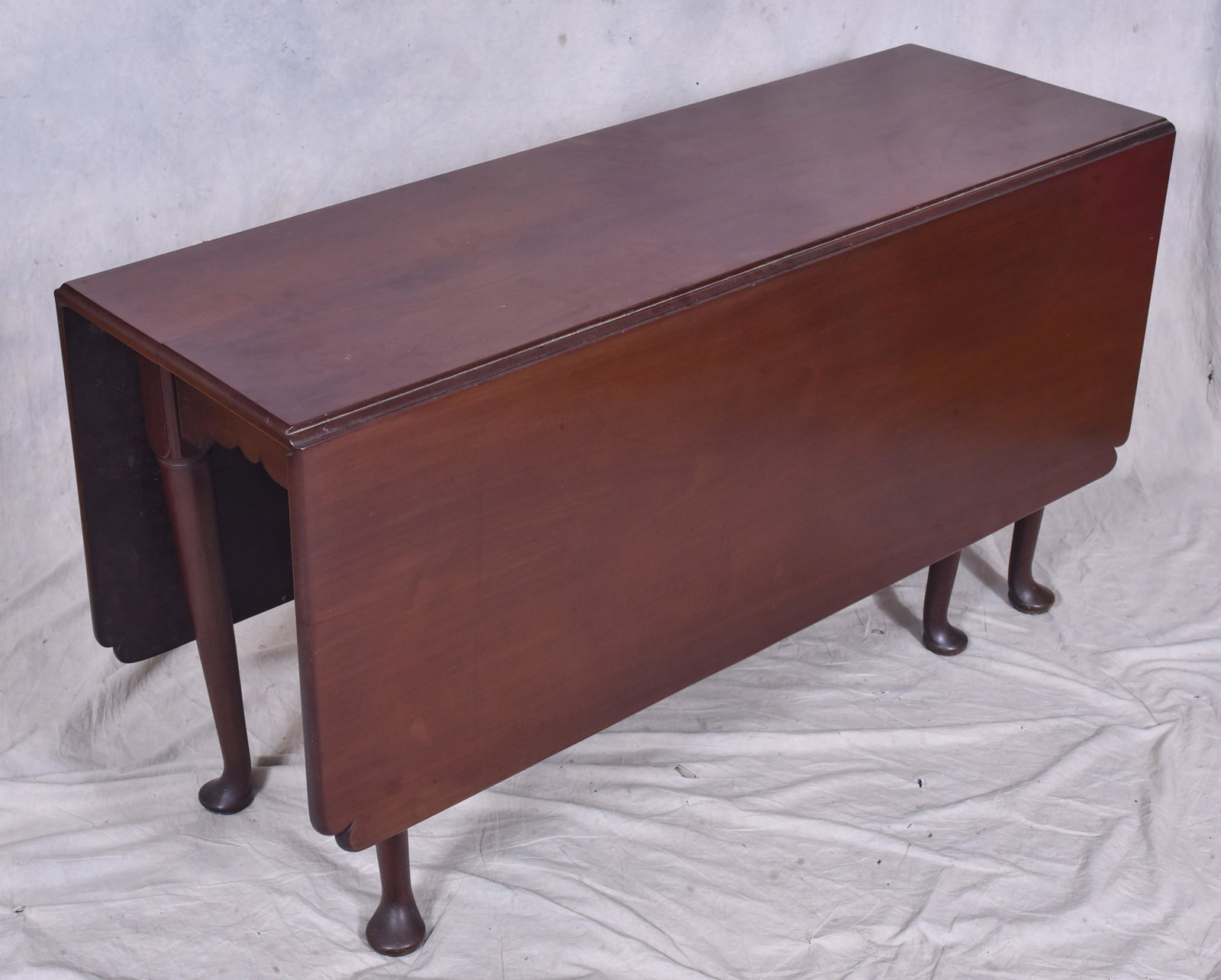 Mahogany Queen Anne Drop Leaf Dining Table: Mahogany Queen Anne drop leaf dining table, rectangular leaves with cut corners, 6-leg gateleg base, turned Queen Anne legs with pad feet, scalloped ends in apron, 53-1/2" x 17" w, 19" leaves