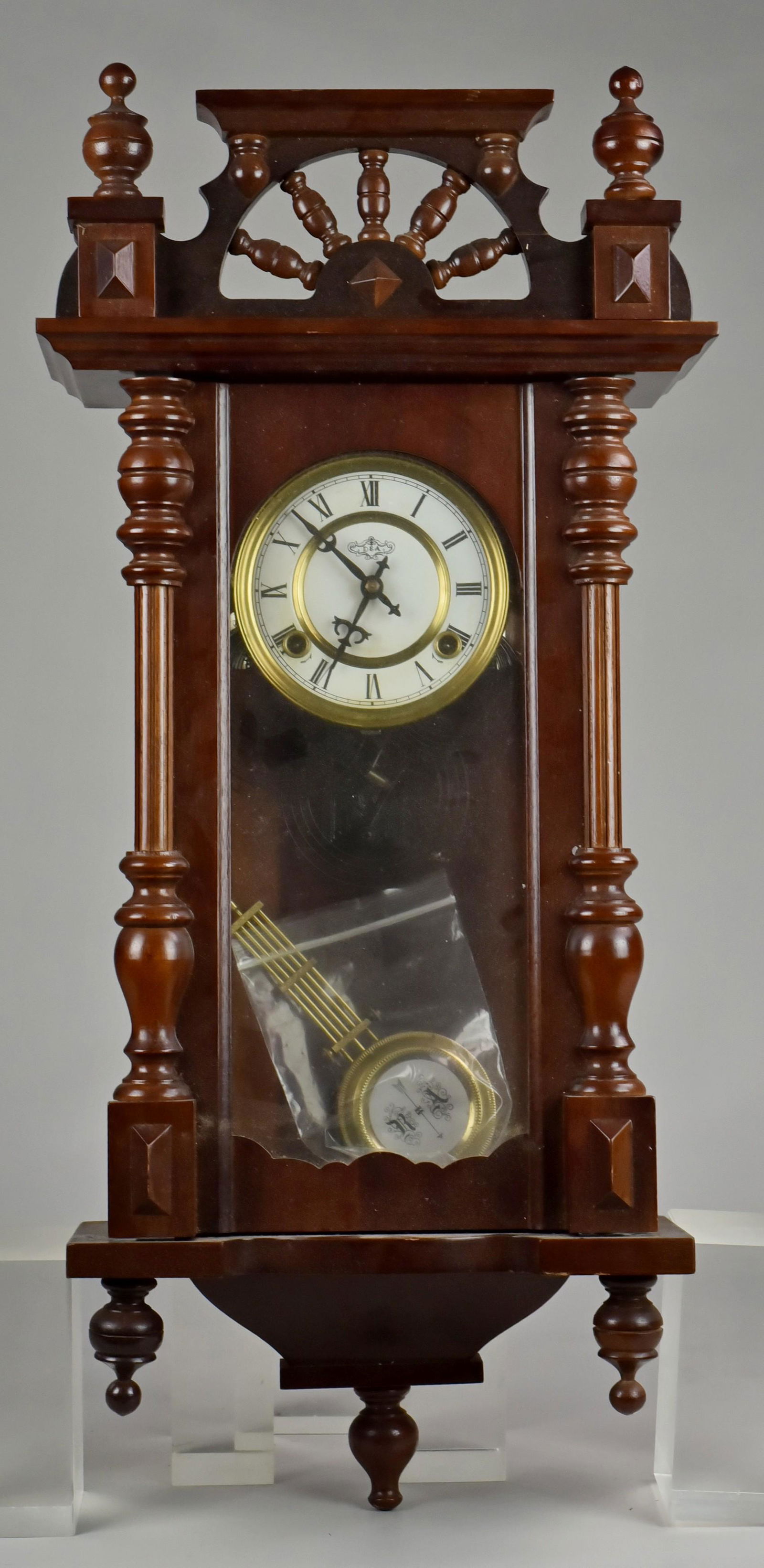 D&A Wall Clock: D&A Wall clock, wheel with spokes crest, with key & enameled pendulum, 30" h x 14" w