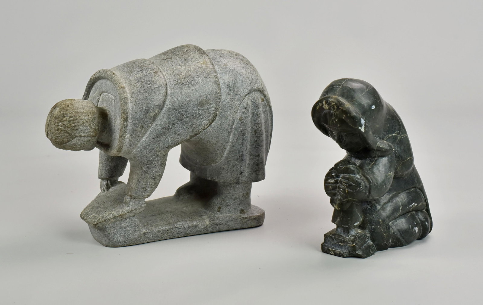 (2) Inuit Figures: (2) Inuit Figures Including: Woman Holding Figure and Man Bending Over Signed E91171 (Largest Measuring 9-1/2" l x 4" w x 8" h)