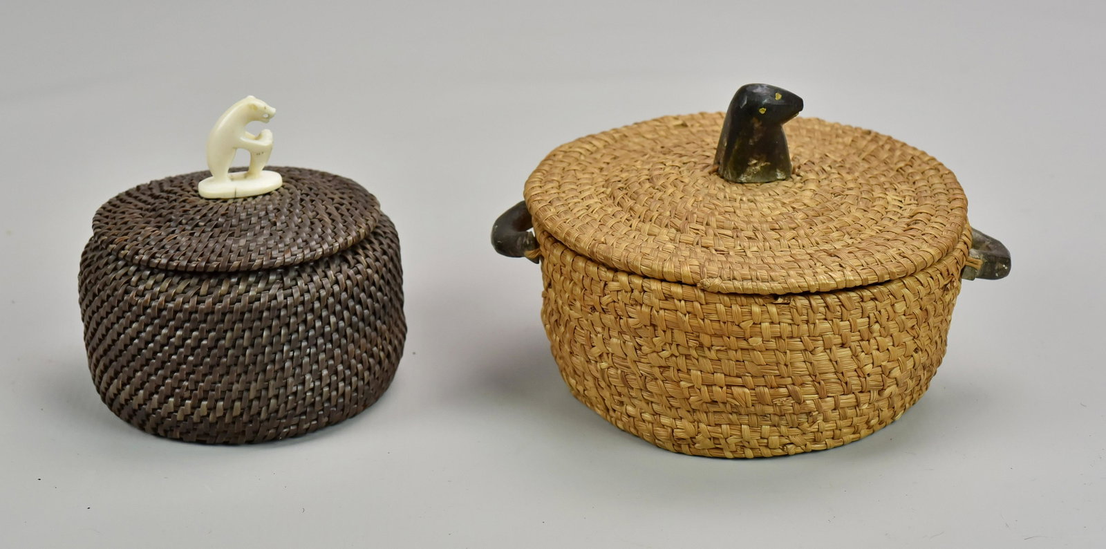 (2) Eskimo Baskets: (2) Eskimo baskets c/o woven basket with soapstone seal head and handles, 6" diam, and baleen basket with polar bear and seal at top, 4" diam.