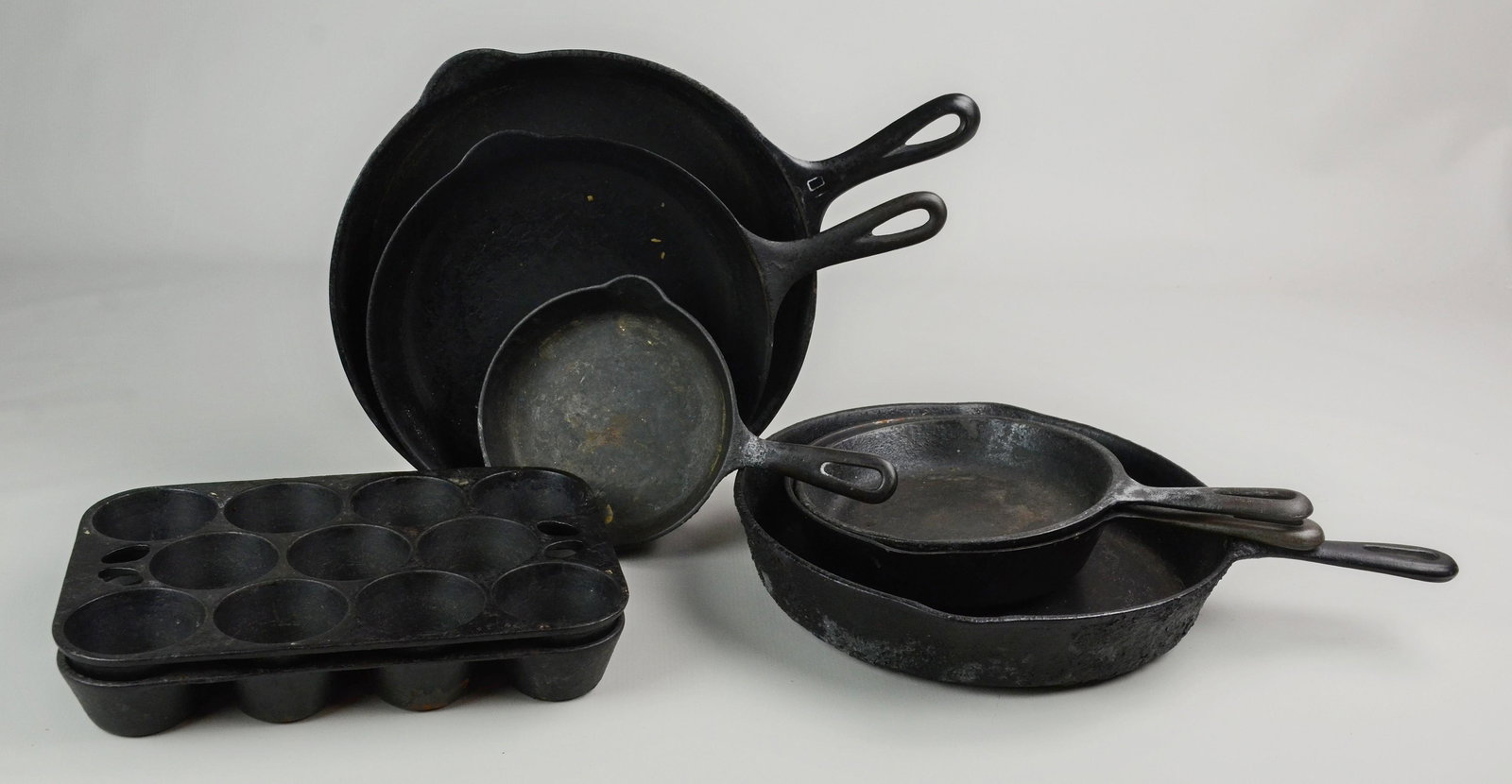 (8) Pcs Cast Iron Cookware: (8) Pcs cast iron cookware, c/o (3) Griswold skillets (#10, #7, #3), Wagner Ware skillet (#5), (2) unmarked skillets (11-3/4" dia, 7-7/8" dia), (2) 11-hole muffin pans marked USA
