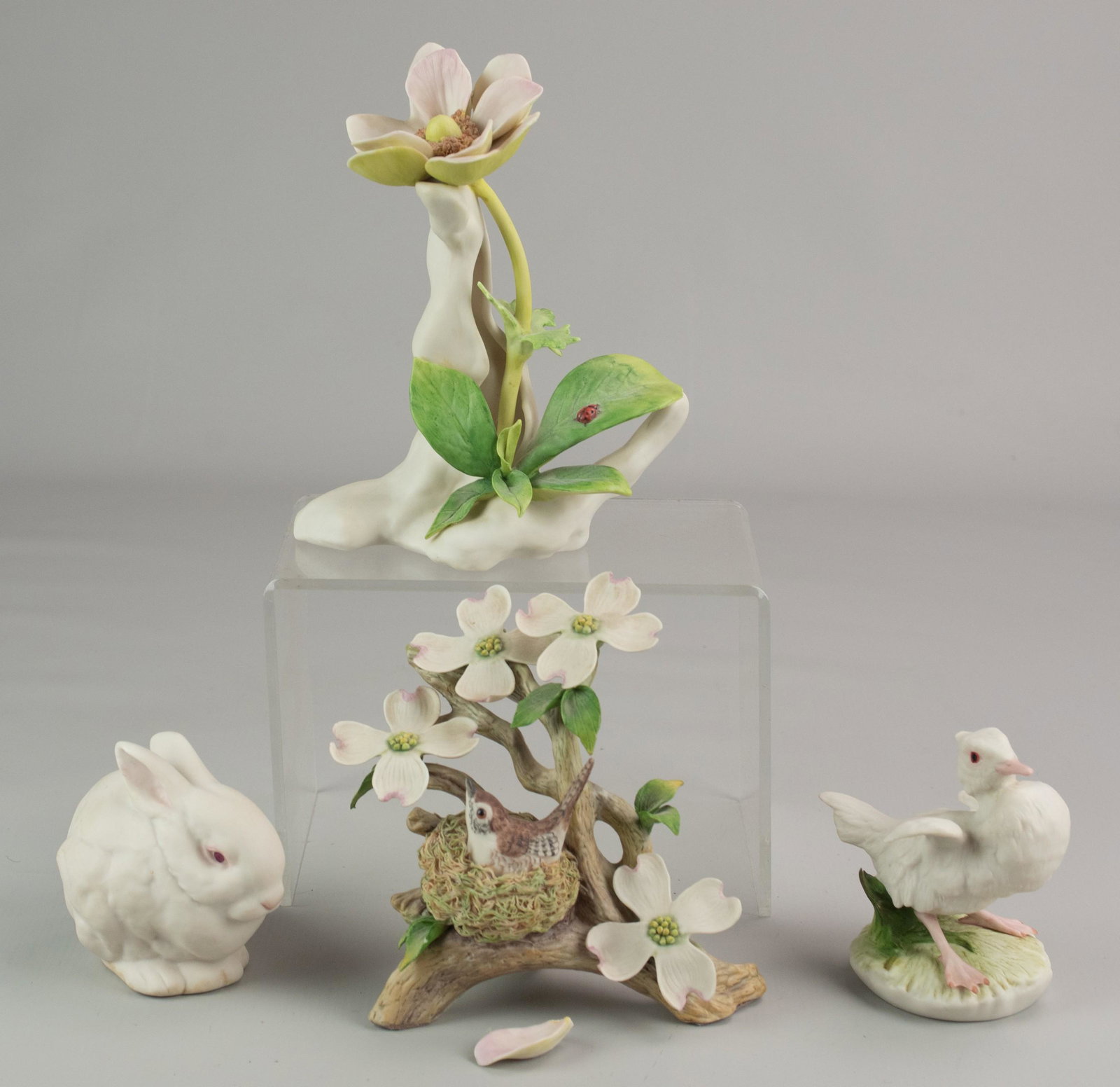 (4) Cybis Porcelain Figures: (4) Cybis porcelain figures c/o a "Mr. Snowball", 4", " duck Baby Brother", 4", Wood Wren in Dogwood, chipped leaf at back, 5-1/2" and Windflower with Ladybug, one petal needs re-attached, 7".