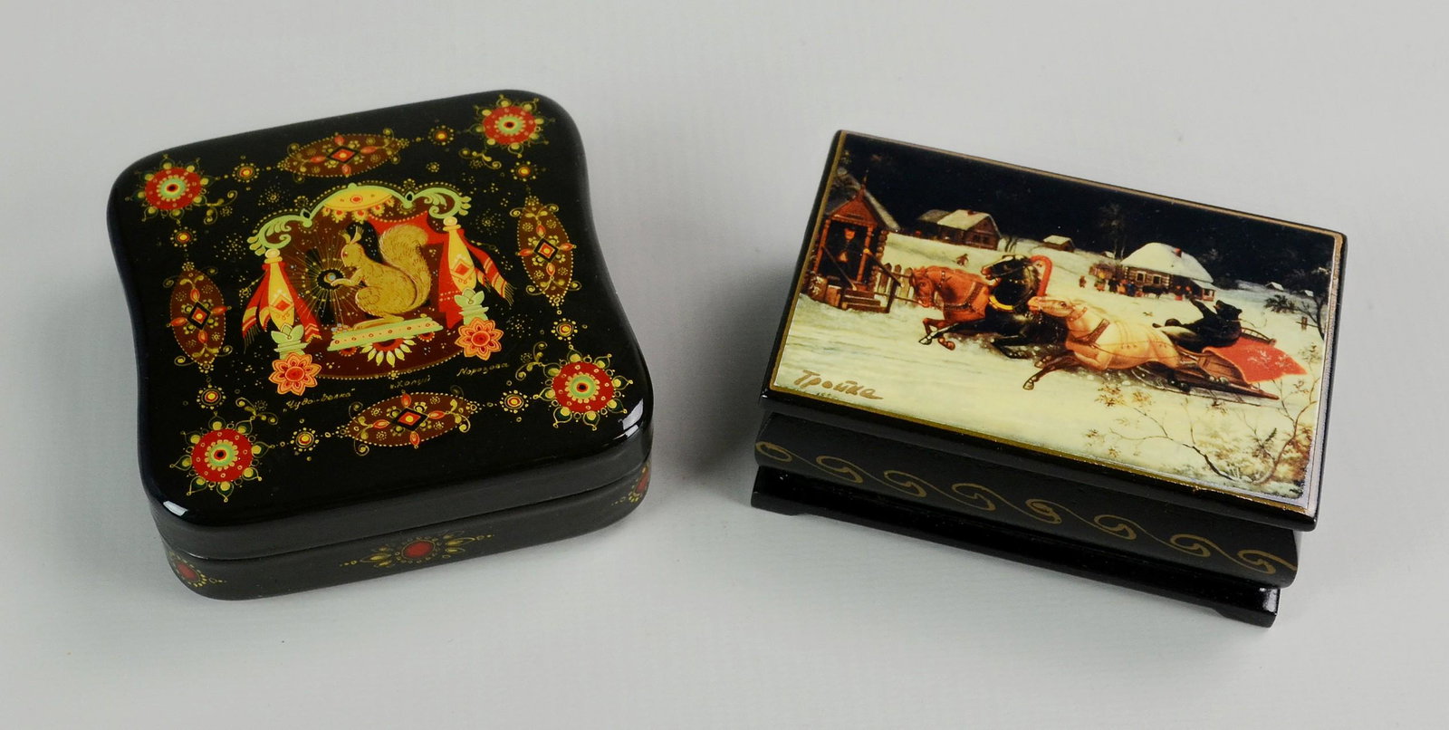 (2) Russian Lacquer Boxes: (2) Russian lacquer trinket boxes, artist signed, c/o Magic Squirrel (3-3/8" sq x 1-1/4" h), bear on sleigh rider with COA (3-1/2" x 2-1/4" x 1-3/8" h)