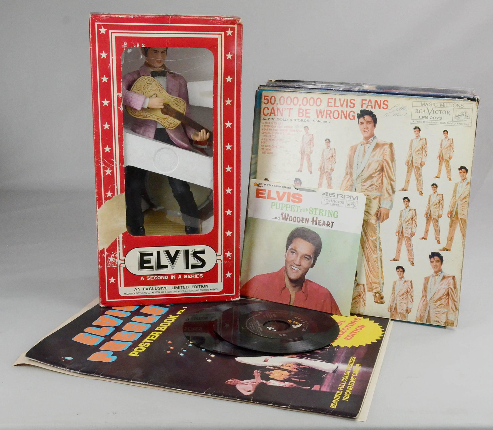 Lot of Elvis Records & Decanter: Lot of Elvis items, including McCormick ceramic decanter in original box, poster book, 1982 calendar, (24) LP vinyl record albums, (4) 45 RPM records