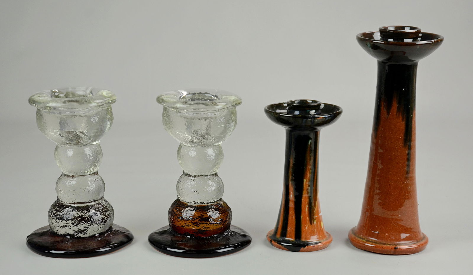(2) Pr. Modern Candlesticks: (2) Pr. Modern candlesticks c/o Timo Sarpaneva style clear and ambler glass textured sticks, 6-3/4" and A.R Cole glazed pottery candlesticks, 9-1/2" and 6", no flaws to note.