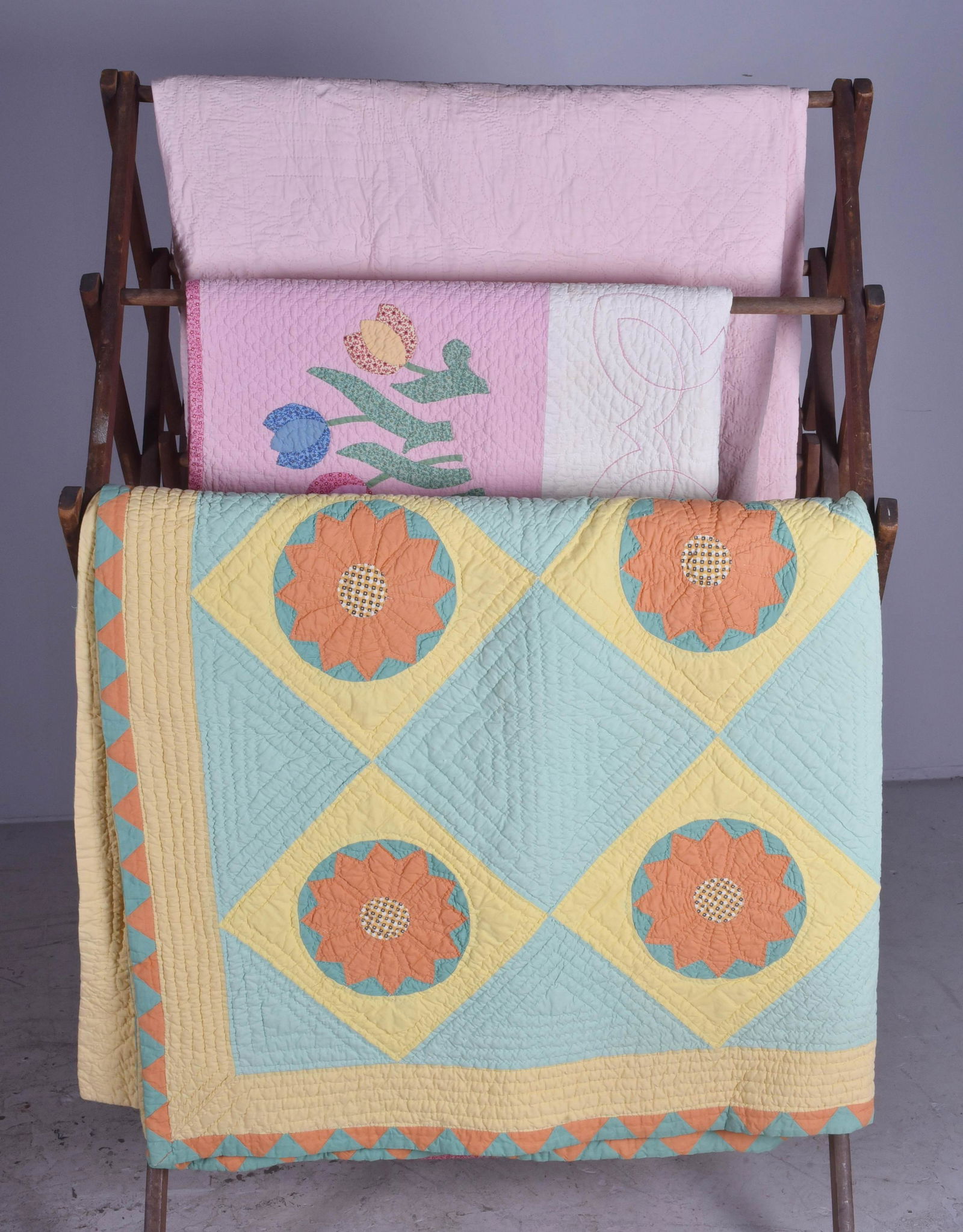 (3) Vintage Hand and Machine Sewn Quilts: (3) Vintage hand and machine sewn quilts c/o quilted mint and blush, hand pieced and hand sewn floral quilt in orange, yellow, green and geo, 77" x 67" and hand pieced and hand sewn tulip block quilt.