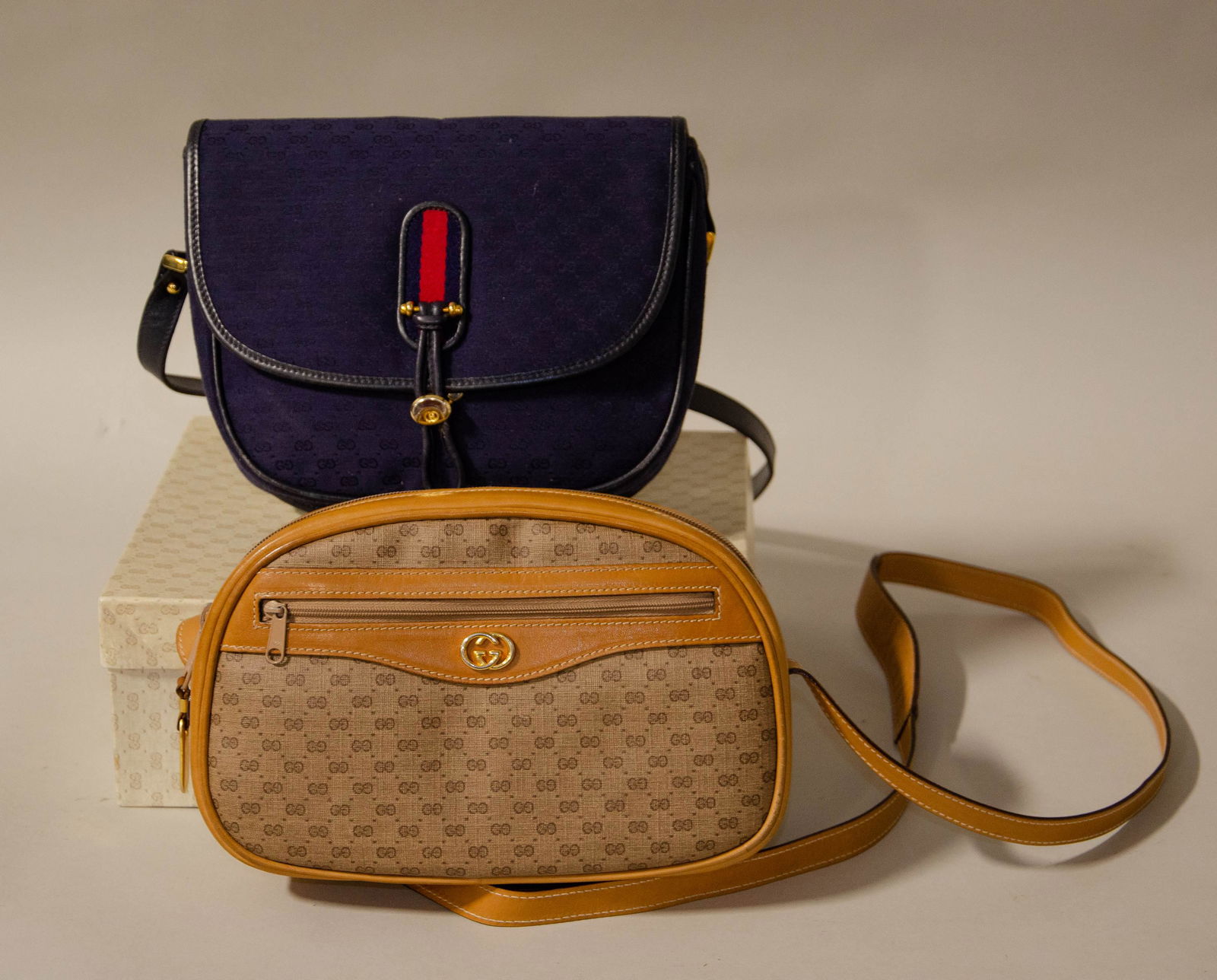 (2) Vintage Gucci Monogram Purses: (2) Vintage Gucci monogram purses c/o navy Gucci monogram purse, saddle bag form with gold hardware and tan and brown monogram Gucci crossbody with interlocking gold G hardware, both approx 9" x 7-1/2