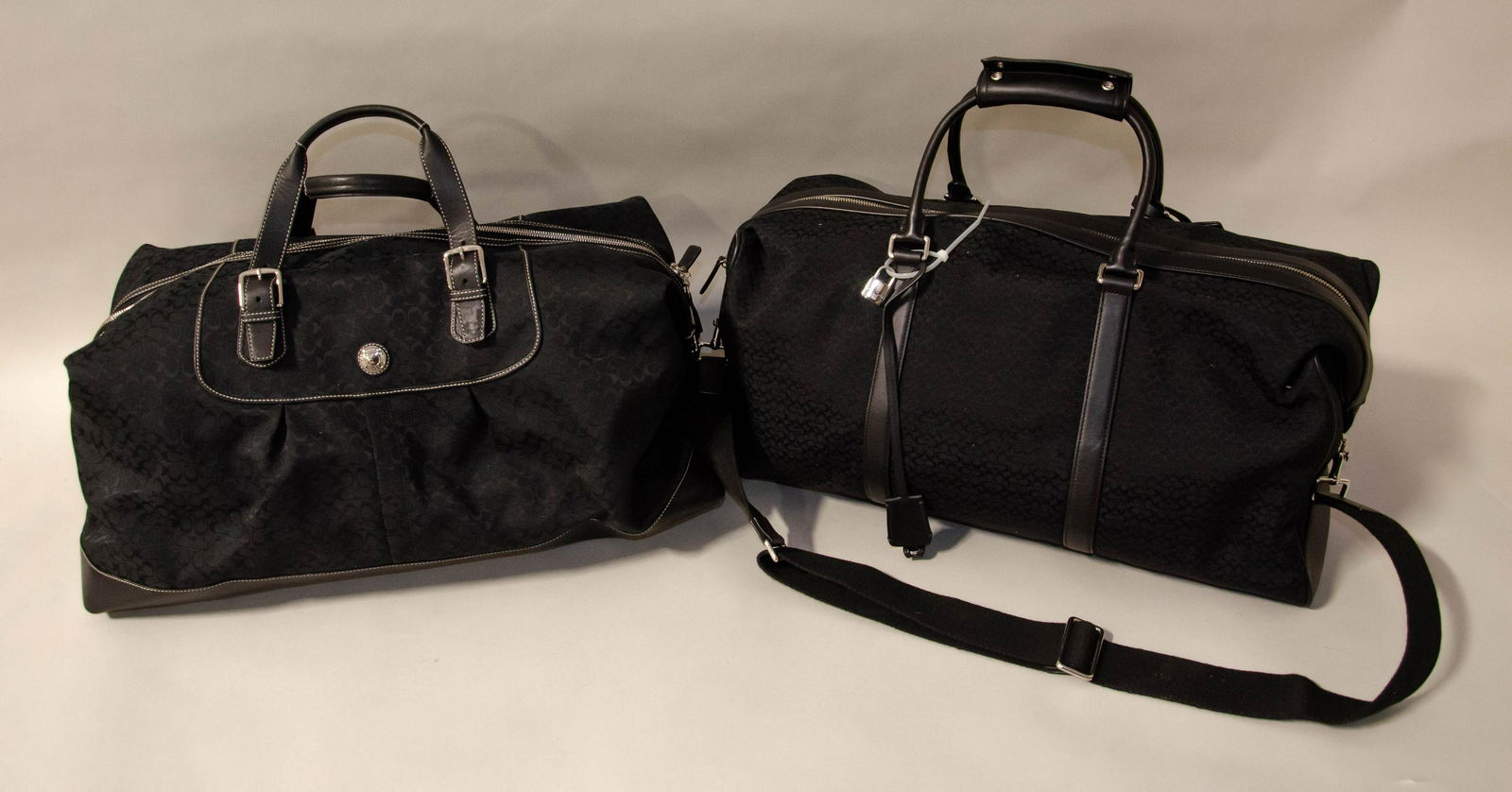 Signature Collection Coach Duffle and Weekender: Signature collection Coach duffle and weekender c/o (2) oversized double black leather handled travel bags in water repellant stain resistant monogram jacquard, Both bags have silver hardware, exterio