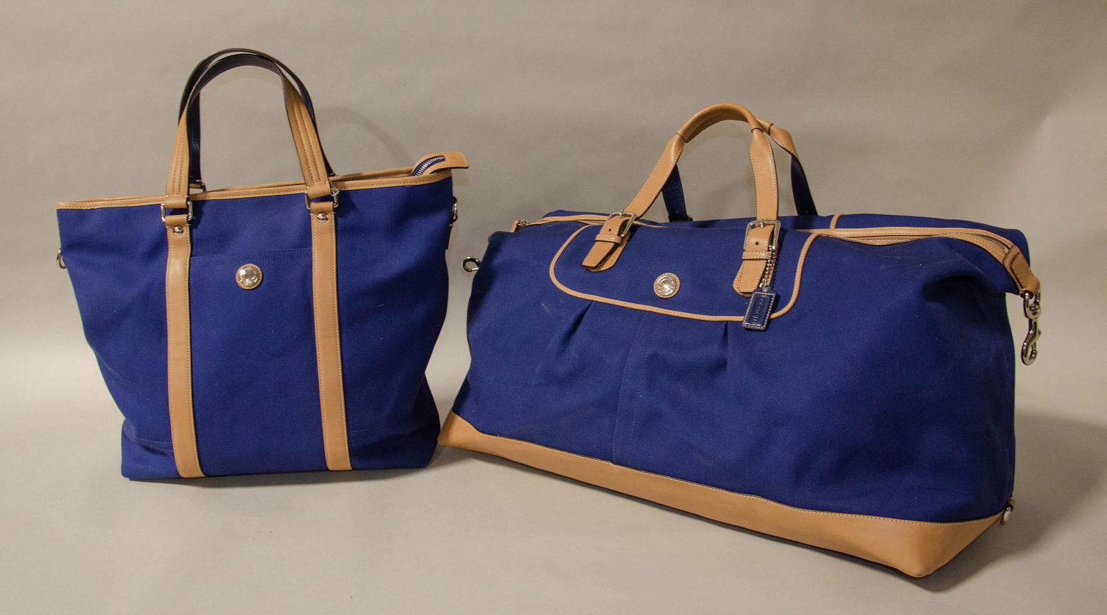 Canvas and Leather Coach Duffle and Tote: Canvas and leather Coach duffle and tote c/o navy canvas bodied oversized duffle with tan leather trim, corners, handles and detailing with silver hardware and shoulder strap, 28" and navy canvas bodi