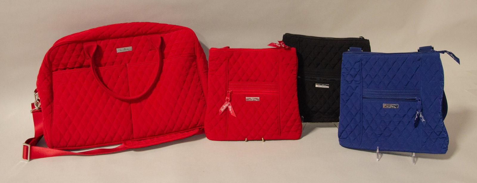 (4) Quilted Solid Vera Bradley Bags: (4) Quilted solid Vera Bradley bags c/o red quilted weekender and (3) red, blue and black quilted cross body bags with (1) black coordinating wallet.
