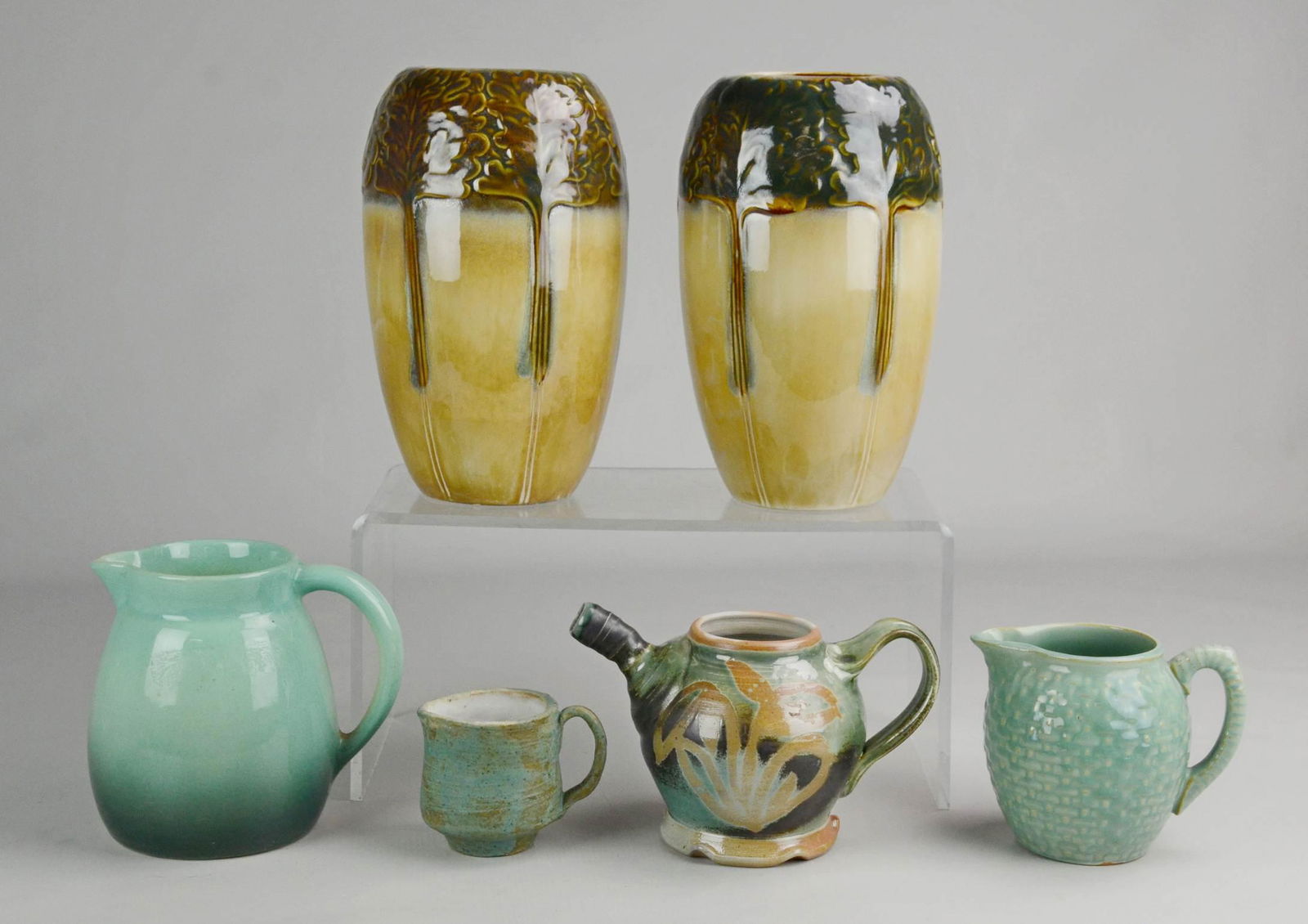 (7) Pottery Vessels: (7) Pottery vessels c/o (1) Pr Marblehead pottery style tree decorated vases, 9-1/4" h, abstract decorated brown glazed vase, 6-1/2", (3) light teal pitchers and MK signed studio pottery teapot.