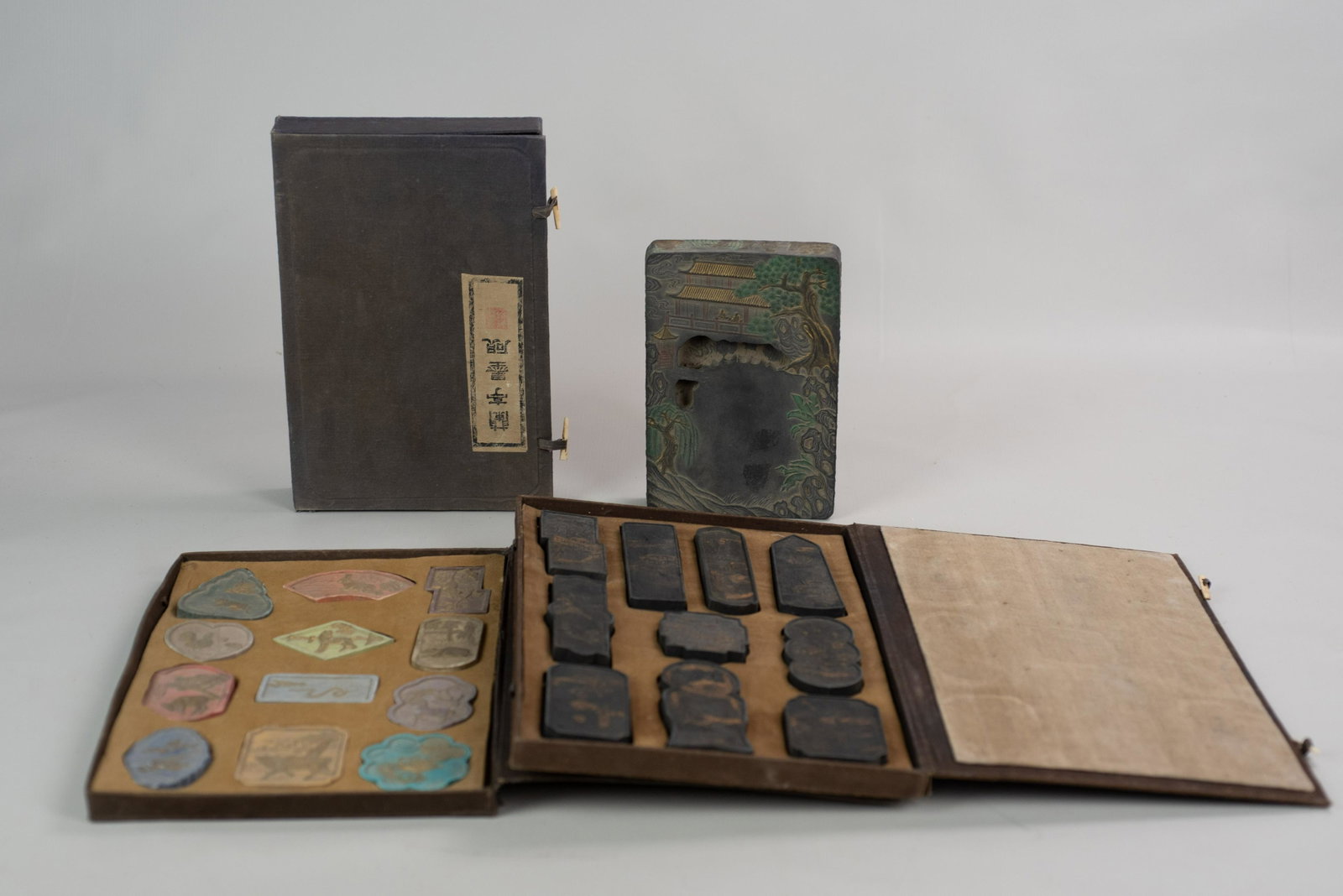 (3) Cases of Chinese Ink Stones: (3) Cases of Chinese ink stones c/o (1) w/9 landscapes in black & gold, (1) w/12 stones colored w/zodiac and a single large stone w/landscape, geese, etc., largest case 12-3/4" x 8-1/2"