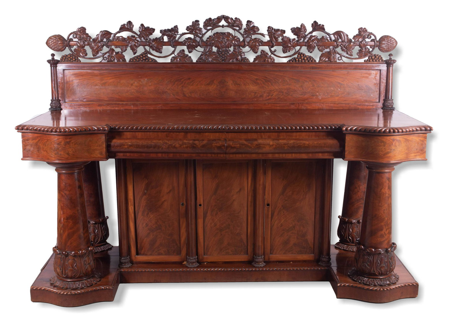Carved mahogany American Federal sideboard,c1820: Carved mahogany American Federal sideboard, the rectangular body with serpentine drawers at the ends flanking a central flat drawer, with a high grape vine carved and paneled backsplash, each end with