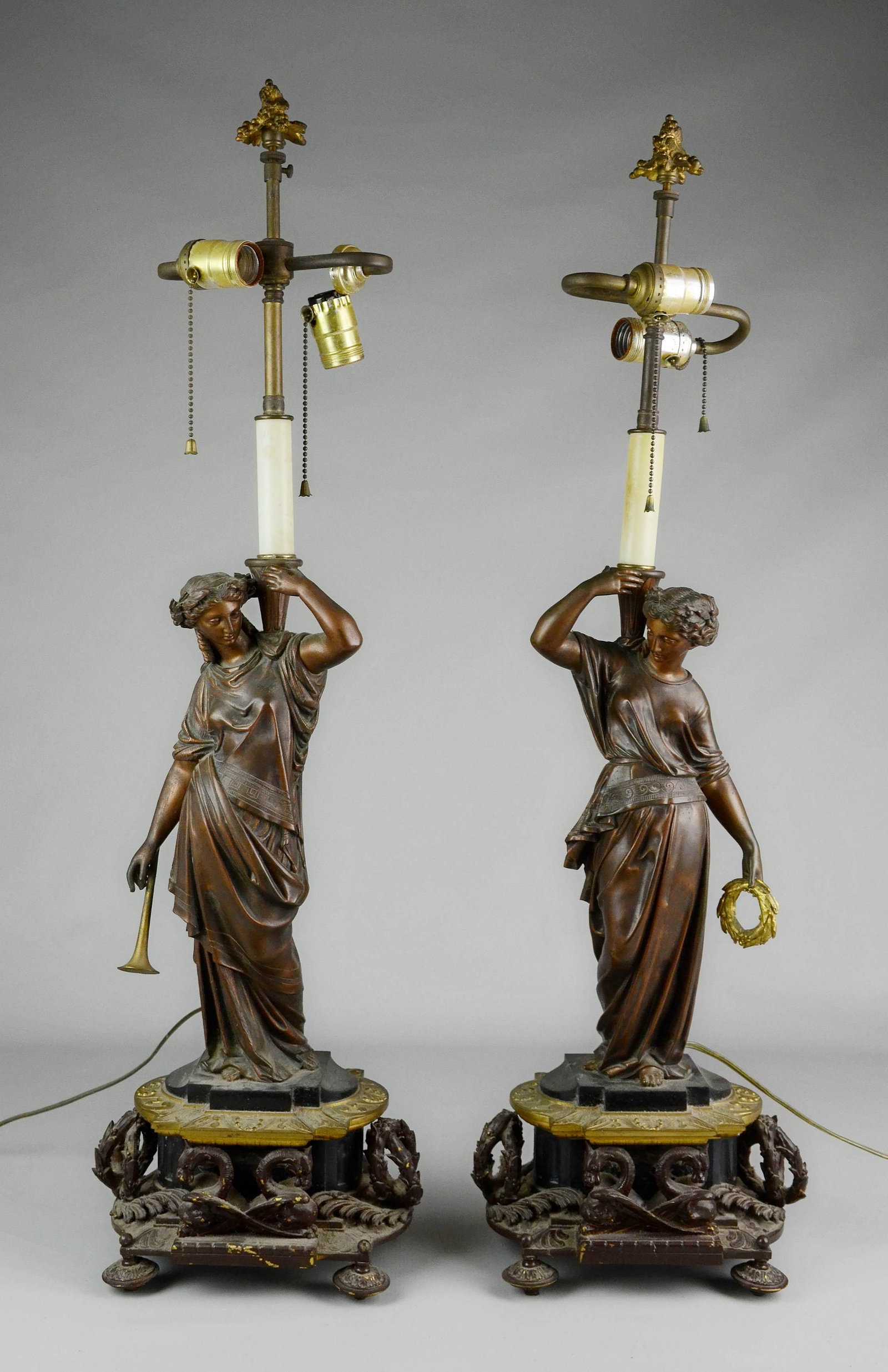 Empire Style Bronze and Marble Lamp Pair: Empire style bronze and marble lamp pair c/o Grecian female figures with trumpet and laurels atop marble and bronze base decorated with laurels and winged beasts, 33" H